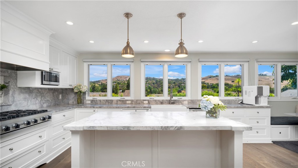 Views, views, views! Nestled in one of Irvine’s most coveted communities, this stunning Napa-inspired 5-BED, 3-BATH DETACHED RESIDENCE perfectly blends timeless charm with elevated, modern luxury. Thoughtfully renovated throughout, the home showcases PANORAMIC canyon vistas overlooking Shady Canyon, Bommer Canyon, and Turtle Ridge: Views you truly have to see to believe! Just steps from Bonita Canyon Elementary and top-rated community amenities, this residence offers a peaceful, PRIVATE setting with UNBEATABLE CONVENIENCE. Inside, an OPEN CONCEPT layout is enriched with WIDE-PLANK HARDWOOD FLOORS, custom archways, SKYLIGHTS, and expansive windows that flood the home with NATURAL LIGHT. The CHEF-INSPIRED KITCHEN features VIKING APPLIANCES, SUBZERO Fridge, CARRARA MARBLE COUNTERTOPS a center ISLAND, and a sunny breakfast nook, all flowing seamlessly into formal and casual living spaces, each anchored by cozy FIREPLACES. A MAIN FLOOR BEDROOM alongside a FULL BATH offers ideal guest or multigenerational living. Upstairs, the SPACIOUS PRIMARY SUITE features a LARGE WALK-IN CLOSET, SPA-LIKE ENSUITE BATHROOM, and WALK-IN SHOWER, while additional bedrooms provide versatility for family, guests, PLUS A DEDICATED HOME OFFICE with CUSTOM BUILT-INS. Outside, a WRAPAROUND BACKYARD sets the stage for alfresco dining, evening relaxation, and FRONT-ROW SUNSET VIEWS. Enjoy EASY ACCESS to resort-style community amenities including pools, spas, tennis courts, playgrounds, and scenic hiking trails. All this, plus close proximity to award-winning Irvine schools (UCI, University High, Rancho San Joaquin Middle, and Bonita Canyon Elementary) as well as world-class shopping and dining, Laguna Beach & Newport Beach, and John Wayne Airport.