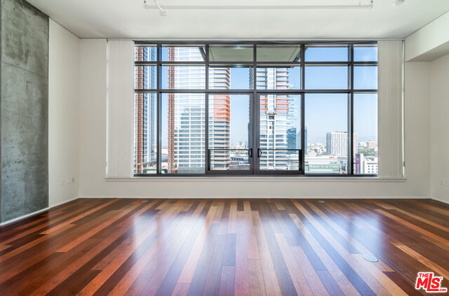 If you've been searching for a lease that feels different from the rest, discover Unit #1606 at Luma, a premier luxury high-rise in DTLA's Social District. Here, you'll find a home unique in design, ideal for entertaining or relaxing against the stunning backdrop of the city skyline, within a community where residents take pride in homeownership, creating a refined, neighborly atmosphere while keeping you close to the city's energy and conveniences. The 16th floor at Luma offers a design not shared by other floors, featuring soaring ceilings that are much higher than typical floors, adding a sense of volume, airiness, and architectural distinction to your home. This spacious one-bedroom, one-bath residence showcases tall, expansive windows that frame skyline views and open to allow fresh air circulation, filling your home with natural light while connecting you to the vibrant city below. A sliding bedroom enclosure provides flexible privacy while maintaining the open-concept feel. The walk-in master closet offers generous storage, while in-unit laundry provides daily convenience. The modern kitchen flows seamlessly into the living area, making it perfect for quiet evenings or entertaining with the city lights as your backdrop. At Luma, you'll enjoy resort-style amenities, including a 4th-level sun deck with pool, spa, water feature, fire pit, multiple BBQ areas, a fitness center, and 24-hour front desk and security services. On-site management ensures a peaceful, well-maintained environment, and one reserved parking space is included. Enjoy a refined living experience while remaining steps from the best of the Social District, including LA LIVE, Crypto.com Arena, Whole Foods, and countless dining, shopping, and cultural destinations.