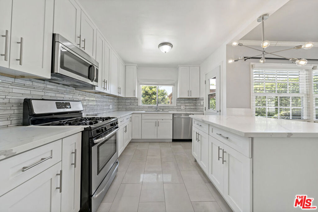 Welcome to this beautiful single-story home located in one of the most desirable neighborhoods of Granada Hills. This charming residence features 3 spacious bedrooms, plus a versatile office that can easily serve as a 4th bedroom, along with 2 bathrooms. The heart of the home is the stylishly remodeled kitchen, complete with sleek quartz countertops and stainless steel appliances, which flows seamlessly into the open-concept dining and living areas filled with natural light. The primary suite offers direct access to the serene backyard through a sliding glass door, creating a perfect indoor-outdoor living experience. The expansive backyard is ideal for entertaining or relaxing, featuring a gazebo, a cozy sitting area, and mature fruit trees and flowering plants. Whether hosting gatherings or providing a safe space for children to play, this backyard delivers both beauty and functionality. Additional highlights include a detached 2-car garage with laundry area and storage/workspace, plus ample driveway and street parking. Nestled on a quiet, well-kept street, this home is close to top-rated schools, popular restaurants, and convenient shopping. With quick access to the 118 and 405 freeways, you'll enjoy both tranquility and connectivity in one perfect location.