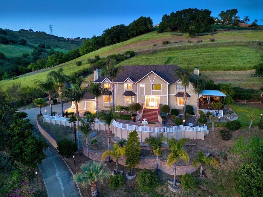 Experience the pinnacle of luxury living at this breathtaking estate nestled on 2.06 acres with panoramic hilltop views. This stunning five-bedroom, four-bathroom retreat boasts soaring ceilings, elegant fireplaces, The Kitchen has marble tile flooring, crown molding, recessed lighting, granite slab counter, tile backsplash and plenty of cabinetry.  There is also floor to ceiling built-in cabinetry with pull-outs for extra storage, under stairs pantry with shelving plus a porcelain sink is set beneath a garden window.  Stainless steel appliances include a  LG French door refrigerator with water dispenser, Miele microwave, warming drawer, oven and dishwasher.  The Island has a granite slab counter with overhang for extra seating, extra storage on both sides, a vegetable sink and a 4-burner gas cooktop illuminated by two pendant lights. Primary bedroom suite has carpet, crown molding, a ceiling fan plus a wood-burning fireplace with marble surround flanked by two hexagonal windows. Walk-in closet with organizers, carpet and a ceiling mount light fixture.  A large window provides natural light. Entertain in style with multiple decks, an outdoor kitchen, and lush landscaping featuring cherry and orange trees.  Graystone, Bret Harte and Leland Schools,.