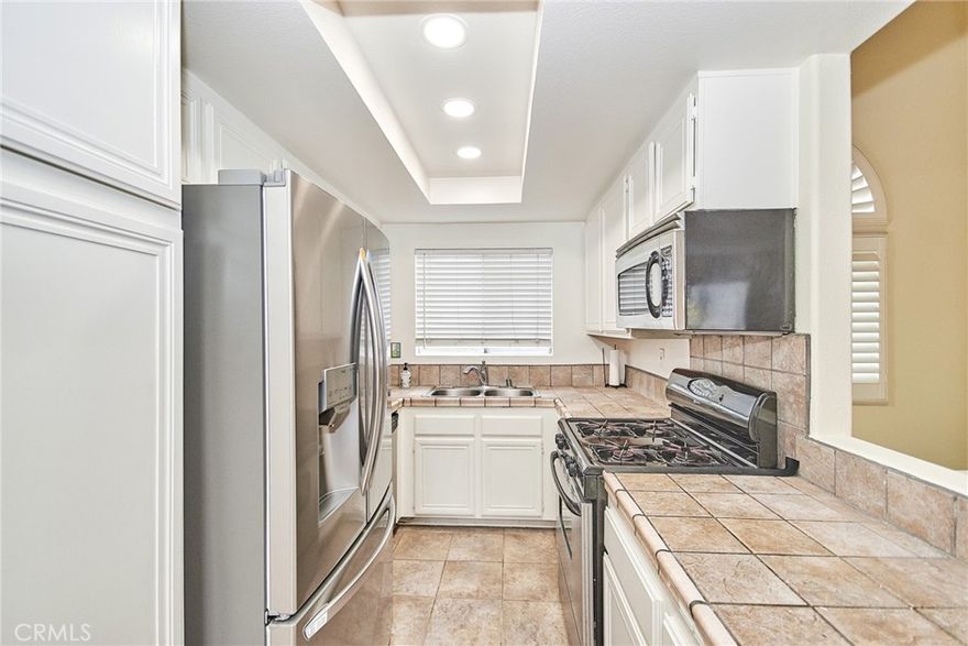 This bright and airy 2 bedroom, 2 bath condo provide the perfect blend of comfort and style.  This unit comes equipped with a washer, dryer and refrigerator, along with a two-car garage and a private balcony. Enjoy a variety of community amenities, including a swimming pool, tennis courts, and a children's playground - all within a beautifully maintained setting.  Conveniently located near hospitals, shopping centers, and vibrant commercial areas. It is also situated within a highly sought-after school district, featuring award-winning blue ribbon elementary, middle, and high schools.