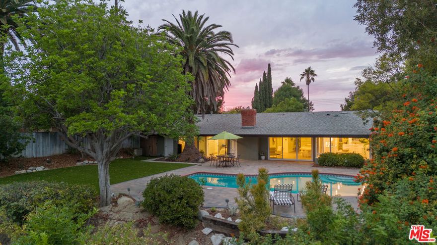 This Mid-Century stunner, in coveted Carlton Terrace, is perched near the crest of the street with sweeping valley and mountain views. Originally built in the 1950s by the neighborhood's developer for himself, this 3,000+ sq ft single-story home on a large private lot blends history, style and entertainer's appeal. Vaulted ceilings and wide plank hardwood floors frame sunlit, open living with designer details, including recessed lighting, built-in speakers and modern updates throughout. The sun-drenched kitchen shines with quartz counters, stainless appliances, custom cabinetry and a breakfast nook, while the adjoining dining room and living room boast panoramic views. The primary retreat features vaulted ceilings, a walk-in closet and a spa-like bath with dual vanities, honed marble tile and a rain shower with a picturesque view through privacy glass of the back yard. Two additional bedrooms with loads of closet space and built-ins share a sleek Jack-and-Jill bath. The family room, which could easily be converted to a 4th bedroom, is wired for surround sound, with a neighboring powder bath and large laundry room with hidden door. The outdoors of this special property are private and sprawling with a classic kidney shaped pool, ever-green yard, new paver patio and endless views. Situated on a street-to-street lot, the oversized garage offers parking for 2 cars plus additional storage. Close to all that's happening in Woodland Hills and Calabasas, with easy access to the 101 and beyond. This property is a truly modern oasis!