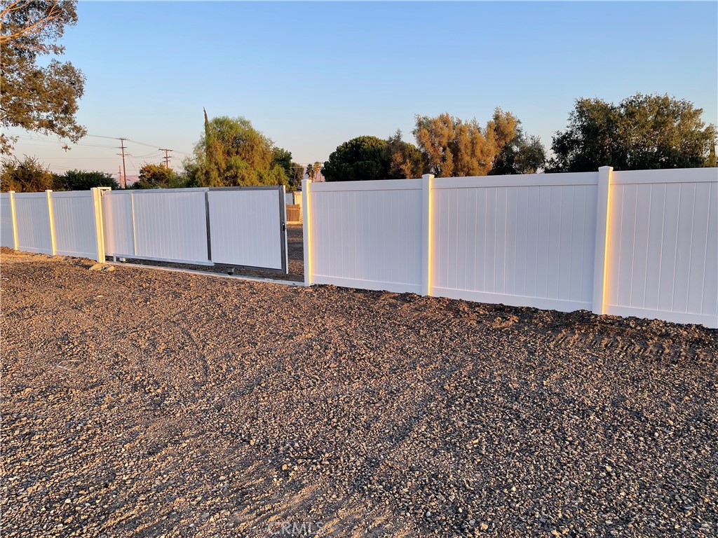 The totally cleared big flat back lot covered by asphalt slags for rent. The new 6 feet tall fence with 24 feet gate just installed. The lot size is 15400 SF ( 140 SF W and 110 SF L ). Potential uses include open storage or other commercial uses. In the front area there are 2 buildings with residential tenants. Zoning Freeway Commercial and Industrial including open air storage, semi-tractor trailer storage, parking, overflow storage, equipment lay down and other industrial/commercial storage needs. Strategic location overlooking the freeway and adjacent to a freeway exit (Cherry Avenue), situated in the heart of the Inland Empire's logistics hub with excellent access to major freeways 10 and 15.
The lot is gated, secure, paved with flexible lease terms. The property is zoned for Freeway Industrial and Freeway Commercial and Industrial. This zoning, combined with the lot's features, opens up a range of potential commercial uses beyond just open storage.
Semi-tractor Trailer Storage/Parking: The large, cleared lot provides ample space for storing trucks, trailers, and other large vehicles, helping logistics companies manage their fleets efficiently.
The lot can be used to store and stage heavy equipment, such as construction machinery for companies with ongoing projects in the Inland Empire.
Fleet Vehicle Parking: Businesses with a large fleet of service vehicles, delivery vans, or corporate cars can use the lot for secure, off-site parking.
Outdoor and Automotive Use.
Vehicle Impound Lot: The secure, fenced nature of the lot makes it suitable for law enforcement agencies or private companies to store impounded or repossessed vehicles. Container Storage: The site can be used to store shipping containers. Automotive Detailing or Repair: While not ideal for a full-scale shop due to the residential tenants in the front, the lot could be used for mobile or outdoor vehicle.
Beyond vehicle storage, the lot's industrial zoning and large size make it ideal for storing various materials and equipment.
The space can be leased to construction companies for storing lumber, pipes, bricks, and other materials for large-scale projects.
The lot could serve as a staging area to store mulch, soil, rocks, and equipment.
