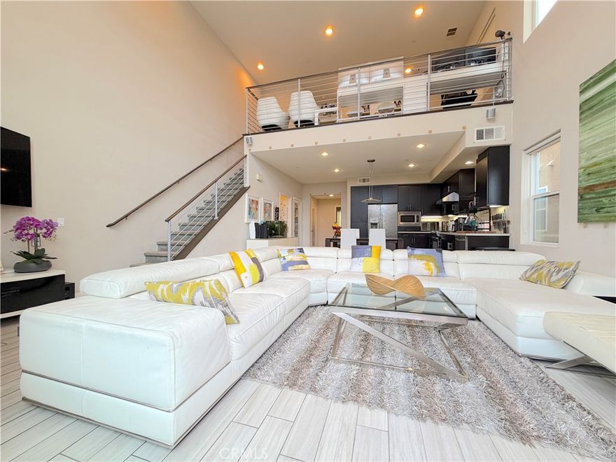 Stunning Tri-Level Live-Work Residence In Artesia Square, Showcasing A Contemporary Architectural Style And A Bright, Airy Ambiance Throughout. This Exceptional Home Features 3 Bedrooms, A Loft, And 3 Bathrooms, Thoughtfully Designed To Balance Comfort, Style, And Everyday Function.
The Entry Level Opens To A Spacious Flex Room Ideal For A Private Office, Studio, Or Lounge, Along With A Guest Half Bathroom, Storage Closet, And Direct Access To The Finished Two-Car Garage. The Garage Is Equipped With A Water Softener, Filtration System, Tankless Water Heater, EV Charger, And Dedicated Solar Components.
The Second Floor Reveals The Heart Of The Home—A Dramatic Great Room Framed By Soaring Vaulted Ceilings And Towering Double-Pane Windows Flooding The Space With Natural Light. The Sleek Kitchen Features Caesarstone Countertops, Stainless Steel Appliances, Dark Cabinetry, Walk-In Pantry, And Convenient Laundry Area. A Private Balcony Extends The Living Space Outdoors And Offers Room For A BBQ, Creating The Perfect Spot To Relax Or Entertain.
Bedrooms Two And Three Are Ideally Positioned Near A Beautifully Finished 3/4 Bathroom, Providing Comfort And Privacy For Family Or Guests.
The Top Level Is Devoted To The Primary Retreat, Highlighted By Impressive City Lights Views, A Sunlit Loft/Office Area, And A Spacious Bedroom Suite. The Primary Bathroom Features Dual Sinks, A Large Soaking Tub, Separate Shower, Private Toilet Area, And A Generous Walk-In Closet. Light, Bright, And Peaceful, This Level Serves As A True Sanctuary.
With 8 Solar Panels, Modern Mechanical Systems, And A Highly Convenient Location Close To Shopping, Dining, Parks, And Major Freeways, This Home Offers A Refined And Sophisticated South Bay Lifestyle.