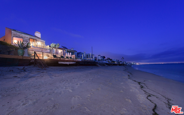 Located on the world famous Malibu Colony Beach on Malibu Rd sits this large lovely private beach house offering breathtaking and unobstructed ocean views. Enjoy the indoor and outdoor coastal lifestyle including the very large landscaped court yard with mature landscaping. With just over 30 ft of sandy beachfront, the open concept floor plan is perfect for entertaining. The home features very high ceilings, exposed beams and hardwood flooring. A large chef's kitchen with center island flows seamlessly into the living area. Enjoy the sounds of the waves and the coastline views from the generous patio and deck. In addition to the 4 bedrooms in the main home, there is also a charming and updated detached guest suite above the garage. With world famous surf points at your disposal and located next to world class shopping and restaurants this property is truly a one-of-a-kind California coastal estate.