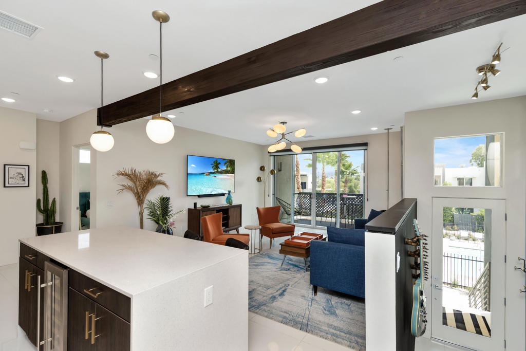 Beautiful 2 bed 2 bath condo right in the center of Palm Springs! One of the best locations within the community, this upper level FULLY FURNISHED poolside condo is filled with custom details, including a cool Jetson style suspended fireplace, a wine fridge, custom gold hardware and tremendous mountain views to the south and west from every room and the balcony! Also includes full solar for super low electric bills. 64@The Riv is a gated community located in the Uptown Design District of Palm Springs, and close to tons of cool restaurants and shops. Some additional features are open concept living area, 9' ceilings with exposed beam, 8' tall sliders onto patio, clerestory windows, quartz countertops and backsplash, custom cabinetry, private community dog park, community electric car charging stations, and a 60' resort stye pool and fireside seating area.