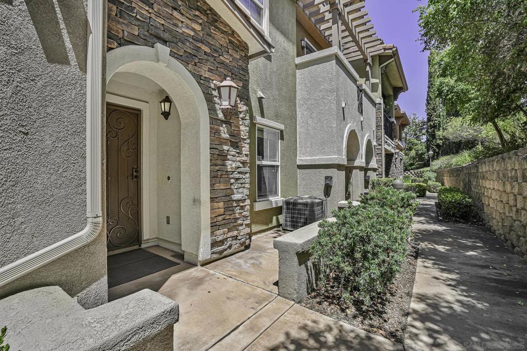You have to see this beautiful townhome in the luxury Treviso Complex. Built in 2008, this stunning tri level offers 3 bedrooms, 3 full bathrooms, 2 sets of laundry, 2 car attached garage and an open concept main living floorplan. Upon entering through the front patio, you will notice the ground floor en suite bedroom and full size laundry room that leads to the attached 2 car garage with storage and sink. The middle floor boasts a gourmet kitchen with an abundance of cabinetry, tv, eat in bar for optional bar dining and granite counter tops which looks over the dining area and large living room. On this floor also is a guest half bathroom. Located on the top floor are both an en-suite second bedroom and the luxury primary suite that offers walk in closet, a stacked washer dryer (in the bathroom), high ceilings and windows looking out onto the greenery. Other upgrades include: high ceilings through, AC, LED bulbs throughout, community pool, community spa, clubhouse and guest parking. Walk to Mission Trails and a short drive to Town Center shopping and the Trolley Stations.