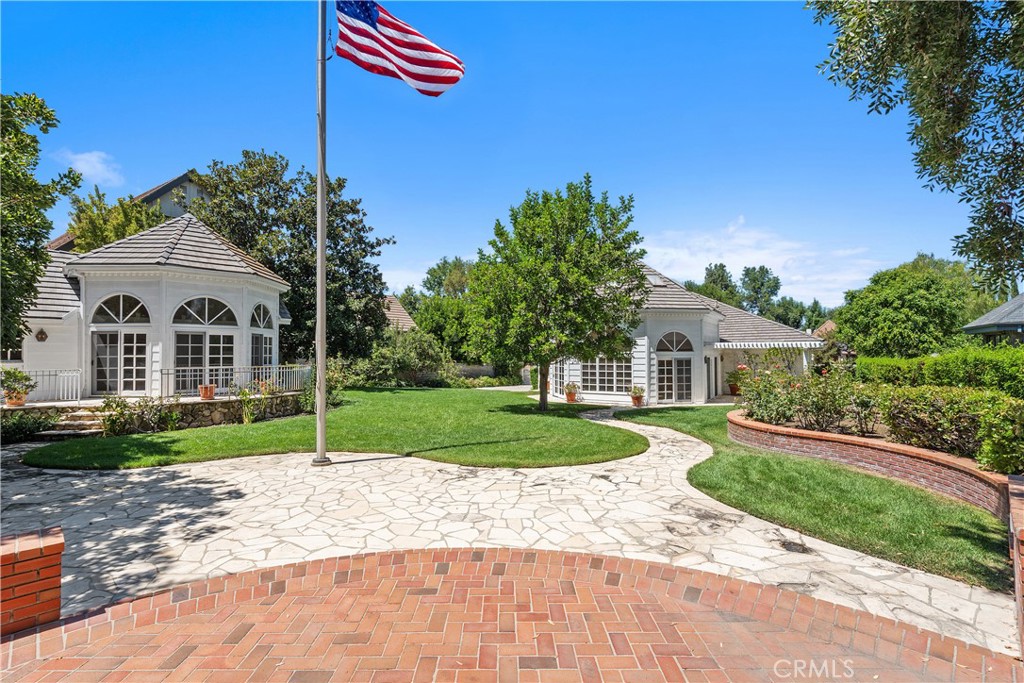 Set on a rare, approx. 36,000 sq. ft. double lot in the exclusively guard-gated community of Westchester County Estates, this property offers Multi-generational living. The main residence is 6,136 sq. ft. (per assessor records) with a 4 car garage. There is an approx. 1,700 sq. ft. studio & workshop with bathroom PLUS an approx. 800 sq. ft. pool house with bath, both of which can be used as a guest house or an ADU providing for Multi-Family living. But wait, there is more! An expansive driveway accessed at Wells Drive leads to an additional approx. 1,100 sq. ft 2-story garage with a loft, a Car Collectors dream with potential to store 8+ cars (with lifts added.) On the market for the first time, this 5-bedroom, 7-bath traditional home is filled with architectural character and timeless craftsmanship. A double-door entry opens to a soaring two-story foyer with oak parquet floors. The elegant living room features a marble fireplace and bay window, while the formal dining room impresses with French doors to a patio, crown moulding, and a butler’s pantry. The chef’s kitchen includes a butcher block island with sink, extensive cabinetry, and a breakfast area beneath wood-beamed ceilings. The spacious family room is highlighted by a massive brick fireplace and granite wet bar. The richly appointed office is finished with oak-paneled walls, built-in shelves, and a stone fireplace. The luxurious primary suite offers a fireplace, sitting area, gym, sauna, oversized walk-in closet, and a private balcony with direct access to the grounds. With a thoughtful floor plan, generous room sizes, and oak floors throughout much of the home, comfort meets elegance at every turn. The outdoor spaces are truly extraordinary. A free-form pool and spa are surrounded by expansive lawns, brick patios and fruit trees—an entertainer’s paradise unlike any other. The pool house has cathedral wood ceilings, a bathroom, a custom bar, a stone fireplace and covered patio with a built-in BBQ! The octagon shaped studio is light and bright with skylights and sliding glass doors that let natural light flow! This home has it all!