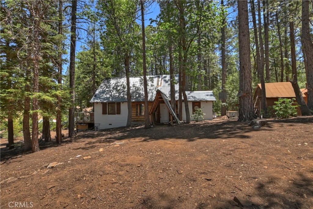 Great opportunity to own a 2-bedroom, 1-bath home on a spacious 28,950 sq. ft. street-to-street lot in the heart of Big Bear Lake. The property includes two private wells, three sheds, and a workshop, with plenty of room for storage and potential use. Surrounded by trees and located in a quiet neighborhood, the home offers privacy while still being close to local amenities. All public utilities are connected. Walking distance to the national forest, and just a five-minute drive to The Village and the lake. Suitable for full-time living, weekend use, or future development.