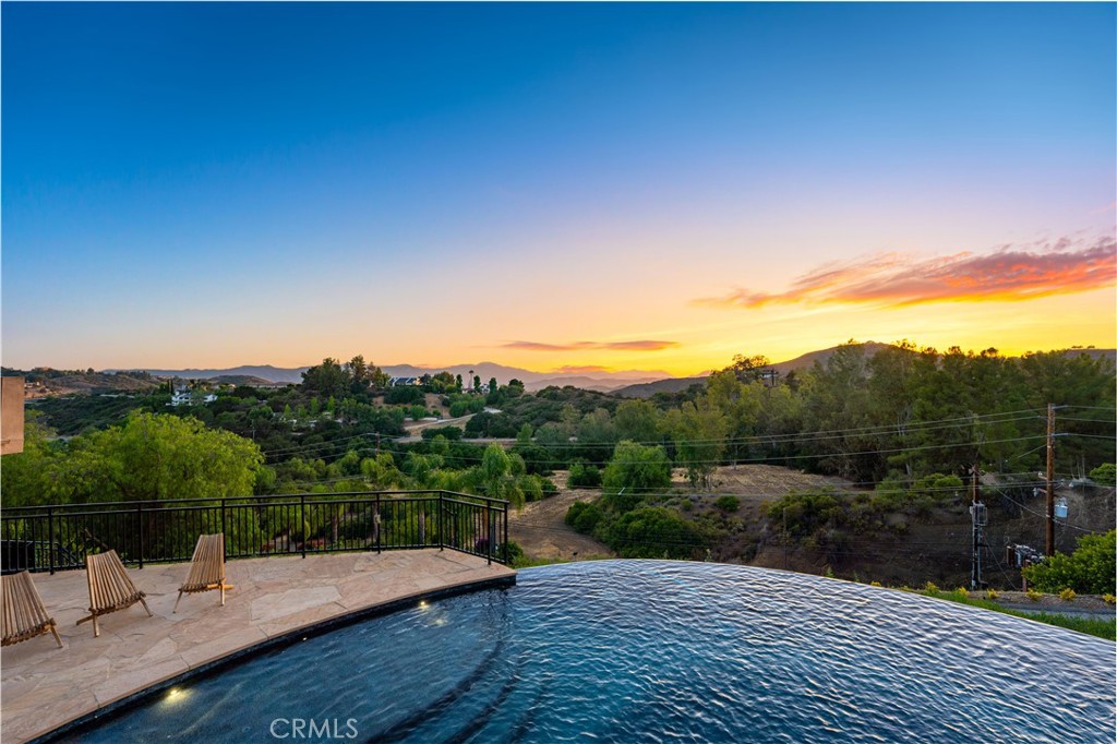 Gated Estate | Fully Landscaped | Unforgettable Views
Tucked into the tranquil beauty of the Santa Monica Mountains, this estate is a rare find—blending architectural elegance with nature’s finest views. Perched just off the iconic Mulholland Highway and resting on nearly an acre of fully landscaped land, this 4,579 sq. ft. residence offers an unmatched lifestyle.Enjoy some of the most breathtaking views in the entire Santa Monica Mountain range, with sunsets off the patio that will truly take your breath away.Originally built in 2008, the home features a brand new negative-edge pool and spa oasis, complete with cascading waterfalls for a true resort-style experience. The outdoor space is an entertainer’s dream, boasting a fully equipped kitchen with a built-in pizza oven, high-end grill, and prep area—all set against a stunning mountain backdrop.
Inside, the chef’s kitchen is outfitted with a Viking 8-burner stainless steel range and an oversized center island, perfect for hosting and everyday living. Throughout the home, you’ll find beautiful hardwood flooring, along with rich alder wood finishes including custom casement windows, French doors, interior doors, and baseboards.The main level offers light-filled living areas with a southwest-facing orientation, while four spacious bedrooms are located on the lower level. There is also ample room to further customize the home to your vision.
Located just seconds from Viewpoint School and within the award-winning Las Virgenes Unified School District, this gated estate is ideally positioned just minutes from Malibu’s beaches and the Calabasas Commons—offering the perfect blend of natural serenity and everyday convenience.