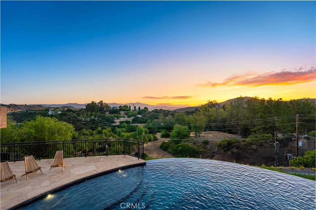 Gated Estate | Fully Landscaped | Unforgettable Views
Tucked into the tranquil beauty of the Santa Monica Mountains, this estate is a rare find—blending architectural elegance with nature’s finest views. Perched just off the iconic Mulholland Highway and resting on nearly an acre of fully landscaped land, this 4,579 sq. ft. residence offers an unmatched lifestyle.Enjoy some of the most breathtaking views in the entire Santa Monica Mountain range, with sunsets off the patio that will truly take your breath away.Originally built in 2008, the home features a brand new negative-edge pool and spa oasis, complete with cascading waterfalls for a true resort-style experience. The outdoor space is an entertainer’s dream, boasting a fully equipped kitchen with a built-in pizza oven, high-end grill, and prep area—all set against a stunning mountain backdrop.
Inside, the chef’s kitchen is outfitted with a Viking 8-burner stainless steel range and an oversized center island, perfect for hosting and everyday living. Throughout the home, you’ll find beautiful hardwood flooring, along with rich alder wood finishes including custom casement windows, French doors, interior doors, and baseboards.The main level offers light-filled living areas with a southwest-facing orientation, while four spacious bedrooms are located on the lower level. There is also ample room to further customize the home to your vision.
Located just seconds from Viewpoint School and within the award-winning Las Virgenes Unified School District, this gated estate is ideally positioned just minutes from Malibu’s beaches and the Calabasas Commons—offering the perfect blend of natural serenity and everyday convenience.