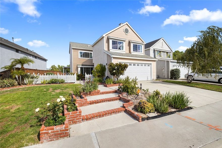 Welcome to the highly sought after Evergreen Ridge neighborhood! Enter into the charming white picket fence of this gorgeous Cape Cod home. This three bedroom, two and a half bath home offers a bright, open floor plan with high ceilings, dual pane windows, central air and heat, and abundant natural light. The spacious living room features a charming bay window, while the upgraded kitchen boasts granite counters, stainless steel appliances, and a breakfast bar perfect for casual dining. Relax in the separate family room with a fireplace and enjoy peaceful hillside views. Elegant travertine flooring flows throughout the main level, with durable laminate on the second floor. The grand primary suite impresses with vaulted ceilings, a double-sized walk-in closet, and a remodeled ensuite bath with dual vanities and a large walk-in shower. Step outside to your private backyard patio to enjoy breathtaking sunset skies. Have the convenience of a 2 car garage with direct access and laundry area. Additional upgrades include remodeled kitchen and baths, newer water heater, alarm system with cameras, whole-house water softener, and energy-efficient dual pane windows. No Mello-Roos! Residents enjoy Lake Mission Viejo amenities such as boating, fishing, beach access, swimming, concerts, and more. More than a home, it's a lifestyle, a community and a place to belong. Make this yours today!