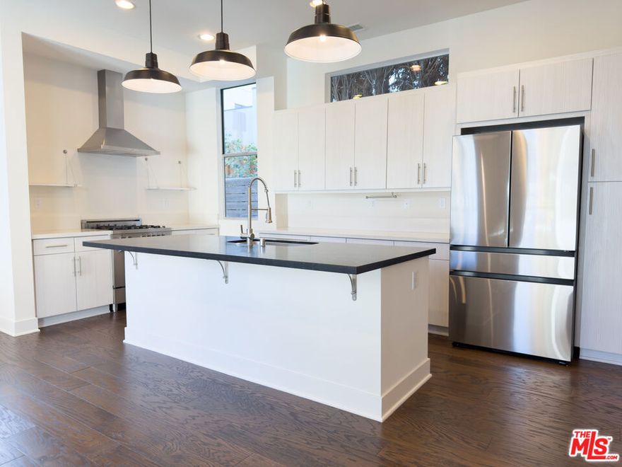 Two blocks (.2 miles) from the Silver Lake Reservoir, this townhouse sits quietly toward the back of the property, surrounded by trees and just steps from the water. The main floor features hardwood flooring throughout, oversized windows that flood the space with natural light, and clean, modern finishes. Upstairs, both bedrooms are generously sized with en suite bathrooms; the main includes double sinks and a large walk-in closet. There's also a powder room downstairs and laundry in-unit for everyday ease. Up top, a newly updated rooftop deck with fresh flooring, lighting, and a pergola  perfect for morning coffee, sunset hangs, or city views at night. You're walking distance to neighborhood favorites: the Reservoir for runs or dog walks, Red Lion Tavern to catch a Dodgers game, Silver Lake Wine for Thursday tastings, Whole Foods, CVS, and Burgers Never Say Die for a fix. Fairly priced, impeccably maintained, and ready to move in. Clean two car garage with remote and plenty of storage space.