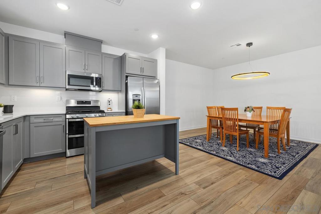 Welcome to this recently built tri-level corner unit townhome, tucked in a serene, well-maintained community. Thoughtfully designed for both function and style, this home offers a seamless blend of modern upgrades and serene surroundings. On the first level, an attached two-car garage—with an EV charger—offers easy access and added convenience. Head upstairs to the open-concept main living space, where beautiful laminate flooring flows throughout. The sleek kitchen features stainless steel appliances, modern grey cabinetry, recessed lighting, and a stylish butcher block center island—perfect for casual meals or entertaining. The kitchen connects to a spacious dining area that overlooks the bright, airy living room framed by sunlit windows that bathe the space in natural light. A convenient powder room completes the second floor. On the third floor, retreat to the generously sized primary suite with a spa-inspired ensuite bathroom featuring a walk-in shower, dual sinks, and a large walk-in closet. A secondary bedroom also offers its own private ensuite with a tub-shower combo—ideal for guests or family. Upgrades abound, including paid solar, plantation shutters, and full Smart Home features: smart lighting, smart thermostat, smart garage access, tankless water heater with remote pre-heating, and connected appliances like the washer, dryer, and dishwasher. As a coveted corner unit with no neighbors on one side, enjoy added privacy and tranquility. The community features low HOA fees, with lush grassy areas with picnic tables, creating a peaceful environment. All this, just minutes from popular restaurants, shopping centers, freeways, San Ysidro High School, Sesame Place, and several local parks.