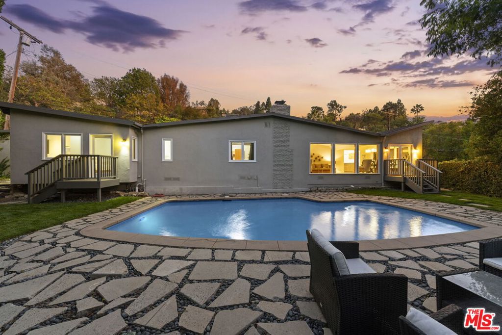 Mid-Century contemporary home sitting on a large, private, corner lot with a beautiful grassy yard and pool.  Quiet and buffered by a huge green hedge and tree tops this Nichols Canyon gem has a large 2 car garage with built-in storage and plenty of street parking on Astral.  Large kitchen connects to sunken family room with an outdoor zen garden and a dining area.  Living room with natural wood floors, a fireplace and huge windows framing the pool and yard.  Primary suite has a large walk-in closet and updated modern bathroom.  Well proportioned guest rooms with walk-in closets and updated bathrooms.   Serene and Creative environment close to Runyon Canyon trails.  A modern take on a classic Hollywood Hills vibe.