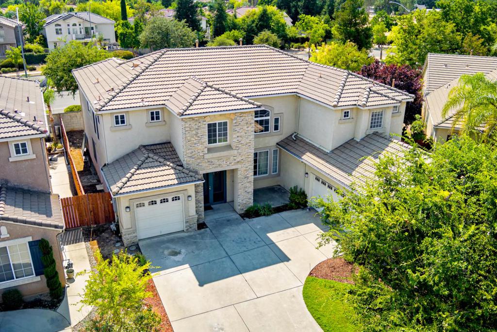 Exquisite Granville home located in the private, gated community of Cantabria. This spacious home offers 3,596 sqft of living space with 5 bedrooms, 3 full bathrooms; plus an office/bonus room with built in cabinetry ideal for a home office. The primary suite is a true retreat with a balcony, dual walk-in closets and an expansive bathroom with soaking tub, shower stall, and dual vanity/sinks. Two of the bedrooms are on the first floor, prefect for extended family or guests. Family gatherings and entertaining is a breeze with access to the patio area from both the formal living room and family room. Recent upgrades include new carpet and fresh paint. Attached, 3 car garage can easily service your parking and storage needs. This turnkey home blends comfort, convenience, and style. Conveniently located near Todd Beamer Park and in the coveted Clovis Unified School District.