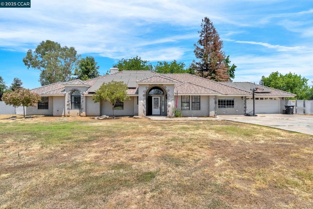 Welcome to this beautifully updated ranch-style retreat in the highly sought-after Madera Ranchos. Situated on a fully fenced acre, this spacious 5-bedroom, 3-bathroom home is anything but cookie cutter featuring architectural charm, soaring ceilings, and custom design details throughout. From the grand arched entryway to the luxury vinyl plank flooring and abundant natural light, every space feels warm, bright, and inviting. The living room makes a bold impression with its dramatic floor-to-ceiling brick hearth, newer pellet stove, wood beam accent, and access to the enclosed sunroom ideal for year-round enjoyment. The kitchen has been tastefully refreshed with quartz countertops, painted cabinetry, and a unique ceiling feature that adds style and character. A secluded bedroom offers flexible space for guests or a home office, while the spacious primary suite includes dual walk in closets, a soaking tub, and backyard views. Outdoors, enjoy your private Pebble Tec pool with rock waterfall, mature trees, and ample space for entertaining or relaxing. Home includes Solar + Battery (PPA), a whole house fan, attached two-car garage, and detached workshop complete this this rare offering. Homes with this level of charm, space, and detail are hard to find.
