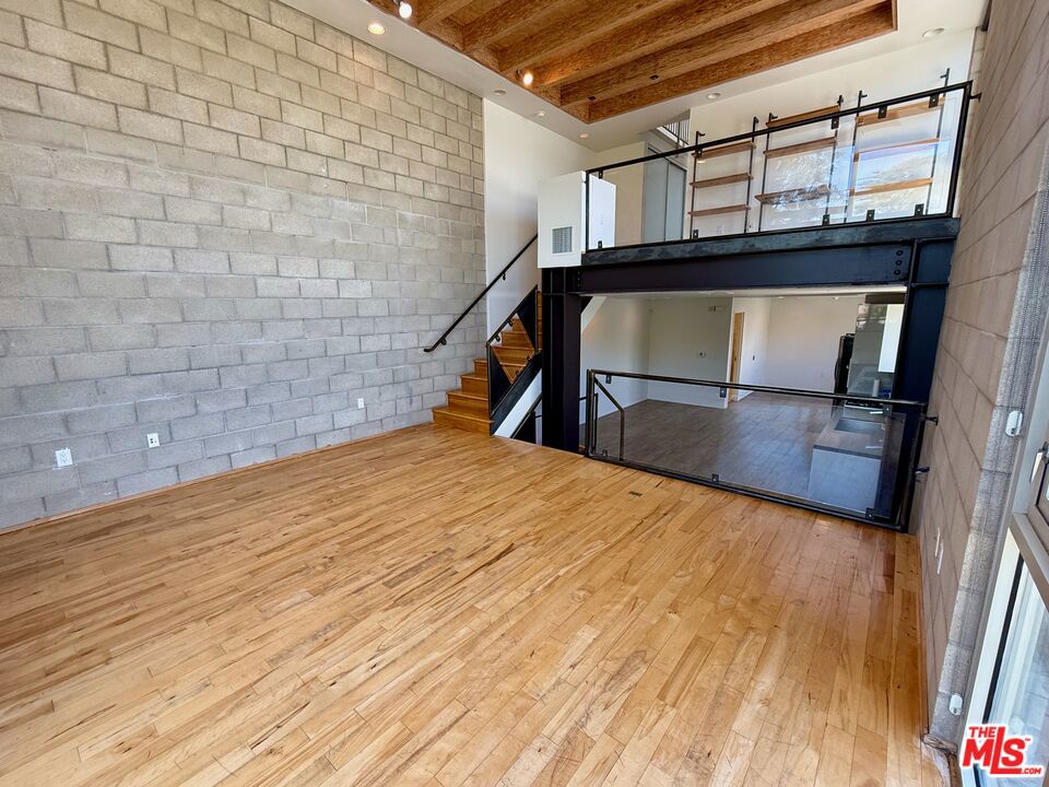 LIVE/WORK LOFT ON LARCHMONT WITH PANORAMIC ROOFTOP VIEWS - Stylish tri-level loft offering sweeping rooftop views of Larchmont Boulevard, the Hollywood Sign, and surrounding cityscape. Located steps from production studios, popular restaurants, and boutique shopping, this modern space features an open floor plan, ultra-high ceilings, and flexible areas for a living room, home office, or additional bedrooms. The sleek kitchen includes contemporary finishes, and the home is equipped with smart features such as low-voltage wiring and whole-home security system. Direct access from a private 2-car garage adds convenience, and LAC2 zoning allows for commercial or live/work use. A rare opportunity for those who want to blend home and work in the heart of the city.