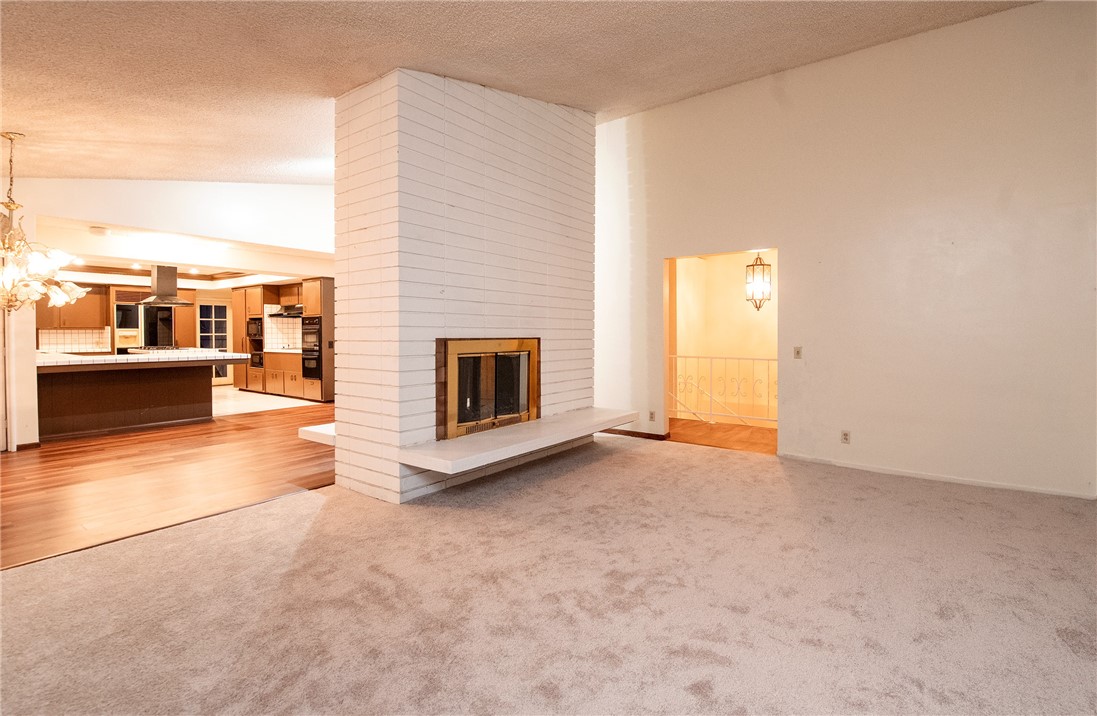 Perched in the hills of Rancho Palos Verdes, this multi-level 5-bedroom, 5-bathroom home sits on a private road and offers sweeping views of city lights, the harbor, the ocean, and the surrounding hills. Step into the main entrance and you’re greeted by a bright foyer with high ceilings, and a hallway that flows to various areas of the home. The dining area showcases an open floor plan, with a see-through fireplace shared with the living room on one side, and the kitchen on the other. The kitchen is equipped with a breakfast bar, center island, and built-in appliances including a double oven, gas range, indoor grill, and dishwasher. From the entry, turning right leads to a half bath and a bedroom; turning left brings you to the main-level primary suite, complete with side-by-side closets, a private bathroom with double sinks, and a balcony. Downstairs, a spacious family room with a fireplace and three-quarter bath, as well as two additional bedrooms, a full bathroom, and a laundry room. Another highlight is a semi-private secondary primary suite featuring a wet bar, a three-quarter bath, and a private deck. Additional highlights include a screened balcony off the dining room and several outdoor patios to capture the property’s breathtaking views. The lot offers privacy and potential for custom landscaping. Parking is abundant, with an attached 2-car garage plus two spaces in front, and a separate 1-car garage at the rear with additional spaces—accommodating up to seven vehicles in total. With multiple access points leading to the outdoor areas, the home invites endless opportunities for entertaining, unwinding, or simply taking in the beauty and tranquility of Rancho Palos Verdes.