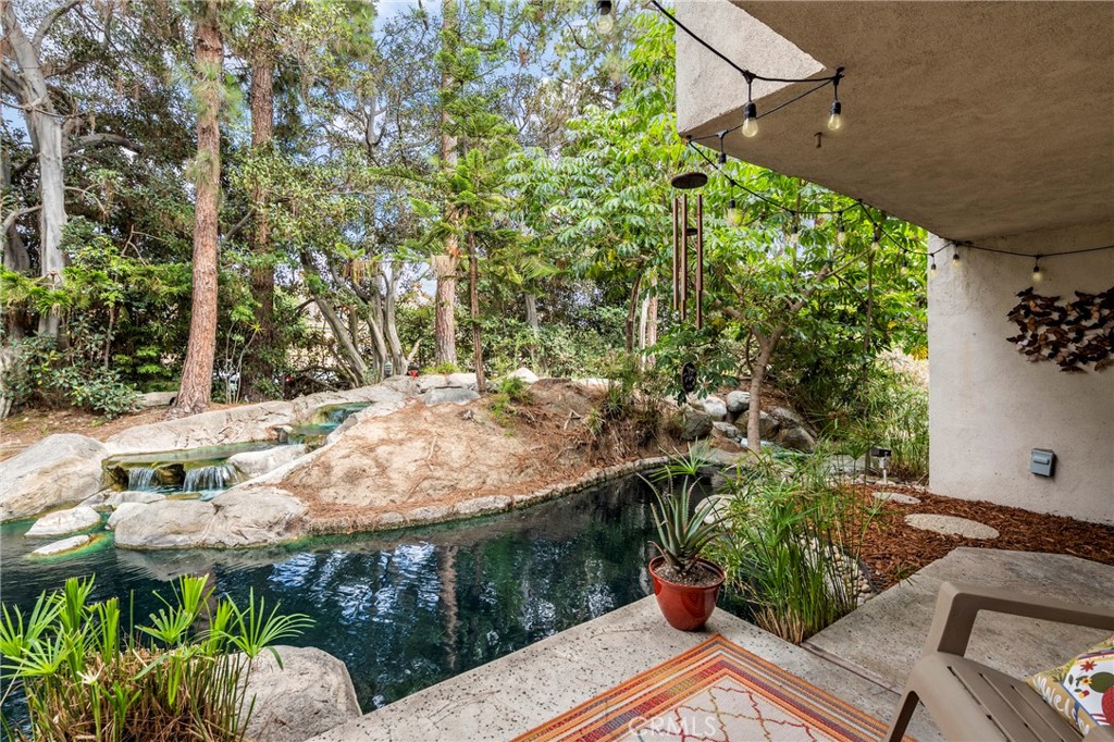 Furnished private & secluded end unit with gated walkway, surrounded by lush landscaped wrap-around stream and waterfalls. Highly updated single-level 1bd Condo with open floor plan, with brand new recessed lighting, enjoy the tranquil and scenic views from every window! Newer Gourmet Kitchen with wood shaker soft close cabinets, quartz countertops, custom glass backsplash with ambient LED lights, white range, and refrigerator. Newer custom bathroom with soft close wood shaker cabinets & linen storage, quartz countertops, newer designer mirror, newer custom ceramic tile throughout! Spacious bedroom with walk-in closet, overlooking nicely landscaped exterior. Cozy up to the Fireplace with newer custom mantel and stone, wood-style flooring. Wood-style blinds in the bedroom, custom wood cornice valances, and a private patio overlooks 2 waterfalls, a peaceful place to call HOME. Completely rebuilt in 2009 with Nest Thermostat, & home security system, plus inside stack laundry unit. Private dry-walled garage with remote garage opener, plus covered parking space. Resort community pool & spa, within walking distance to Starbucks, Dining, TJ Maxx and Home Depot. Great central location easy access to 405/55/73 Freeways and Parks. Perfect yard for a small dog! (Pet-Friendly Community).