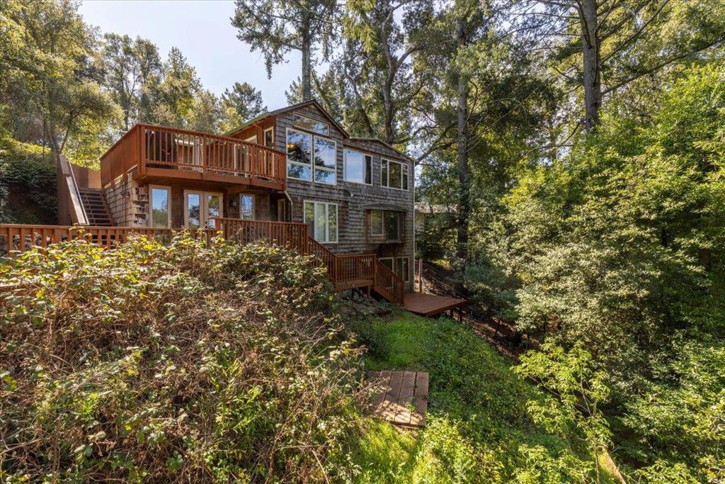 Escape the stresses of Silicon Valley in this serene mountain retreat, where breathtaking views and peaceful surroundings offer the perfect blend of privacy and tranquility. Nestled in the desirable Aldercroft Heights neighborhood, this impeccable home blends modern style with natural beauty, offering stunning indoor-outdoor living spaces and long-range vistas. The light-filled interior features vaulted, beamed ceilings, rich hardwood and stone flooring, and custom woodwork throughout. The spacious great room showcases a wood-burning fireplace with natural stone surround, flowing seamlessly into the updated kitchen with granite countertops, tile backsplash, custom maple cabinetry, and premium appliances including a Bertazzoni 6-burner professional range. The lower levels offer generously sized bedrooms, updated baths, a laundry room, and access to expansive decks that immerse you in the peaceful natural surroundings. Tucked among the trees is a charming separate treehouse perfect for work, play, or quiet reflection. Located just minutes from downtown Los Gatos and served by top-rated Los Gatos schools, with Comcast high-speed internet available this exceptional property provides a rare opportunity to unwind in nature without sacrificing modern convenience.