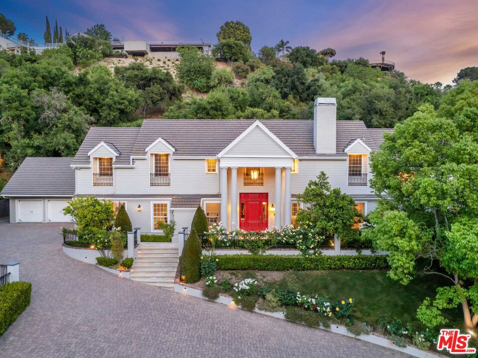 This is where everyone wants to live - Magical Woodvale Road. The prime location in coveted Royal Oaks. Surrounded by $18M estates, this grand traditional offers every luxury amenity. Private hedges and a secure gate offer security. The long wide driveway gently slopes far up off the street, past the massive flat grassy lawn with a gorgeous sun-drenched pool and the Guest House that offers a full bathroom and kitchen. One of the largest flat yards on this fabled street, this is where soccer games or weddings with hundreds of guests are comfortably seated in this pavilion surrounded by towering shade trees. The house with its timeless classic Colonial design has a large circular motor court which is perfect for playing basketball, a three car garage and gorgeous public rooms designed for gracious entertaining. The open floorplan features a large kitchen with center island and bar stool seating adjacent to a breakfast nook with high-pitched ceilings. An elegant 10-seat formal dining with ample natural light thru the charming windows is ideal to host large family dinners. There's a gorgeous step-down living room with a stately marble fireplace mantle, framed by large walls that accommodate a great art collection. One of the best primary suites available features two walk-in closets, high-pitched ceilings highlighted by a skylight, close to secondary bedrooms, and an enormous gym with its own private balcony that overlooks the backyard and the tree studded private yard. The flexible floorplan has two junior suites on the second floor, two en suite bedrooms and a great home office on the main floor. The maid's room off the kitchen can also be a huge mud room. Through a secret hidden door there is a finished attic where the entire classroom can sleep over. It's so great to have all your kids there in the house for those memorable weekends. This is rare opportunity to acquire a large remodeled home on the valley's premiere street.