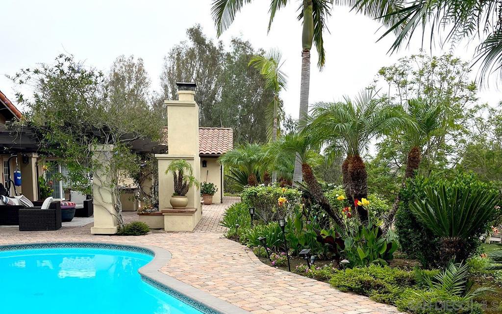 This single-level Hacienda Santa Fe community home features nearly 3600 square feet of living space. You'll find paid-for solar, upgraded windows, doors, and rich hardwood flooring - the home is as functional as it is stylish. The property is designed for both relaxation and fun — enjoy the sparkling pool and spa or unwind under the pergola by the outdoor fireplace. A spacious lawn provides plenty of room for outdoor activities, while the orchard with mature fruit trees completes this exceptional lot.
