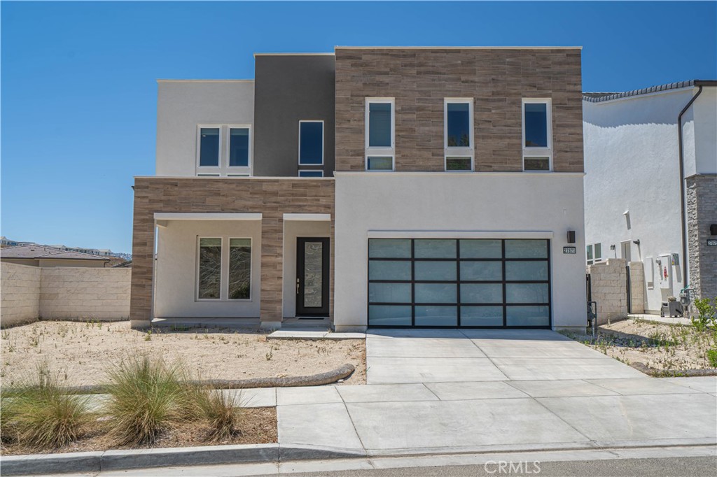 Welcome to 27871 Screenplay Place—an exquisite Toll Brothers Merle model located in the highly sought-after Skylar neighborhood of Valencia’s FivePoint community. Built in 2024, this luxury residence combines modern elegance with thoughtful upgrades, offering 5 spacious bedrooms, 4.5 baths, and 3,903 square feet of finely crafted living space on a generous 7,500 sq ft lot. Just minutes from the 5 Freeway and Valencia Town Center’s Westfield Mall, this home also sits within the award-winning Newhall School District, making it an ideal location for families and commuters alike. Step inside to real hardwood floors flowing throughout the home, anchored by a warm gas fireplace in the expansive great room. The chef’s kitchen is a true showstopper, featuring upgraded cabinetry, dual sliding glass doors that open to the backyard, and top-of-the-line appliances—including a 48" Sub-Zero refrigerator/freezer, a 42" 6-burner Wolf gas range with oven, and an additional wall-mounted Wolf oven. Luxury continues with a zoned dual-unit HVAC system enhanced by a whole-home AprilAire steam humidifier, promoting better respiratory health and preserving your hardwood floors. The LifeSource water filtration system ensures fresh, filtered water throughout the home. A spacious 3-car tandem garage includes an EV charger, providing both practicality and forward-thinking convenience. From its upgraded features to its premium location, 27871 Screenplay Place offers a rare opportunity to own a truly turnkey home in one of Valencia’s most dynamic communities.