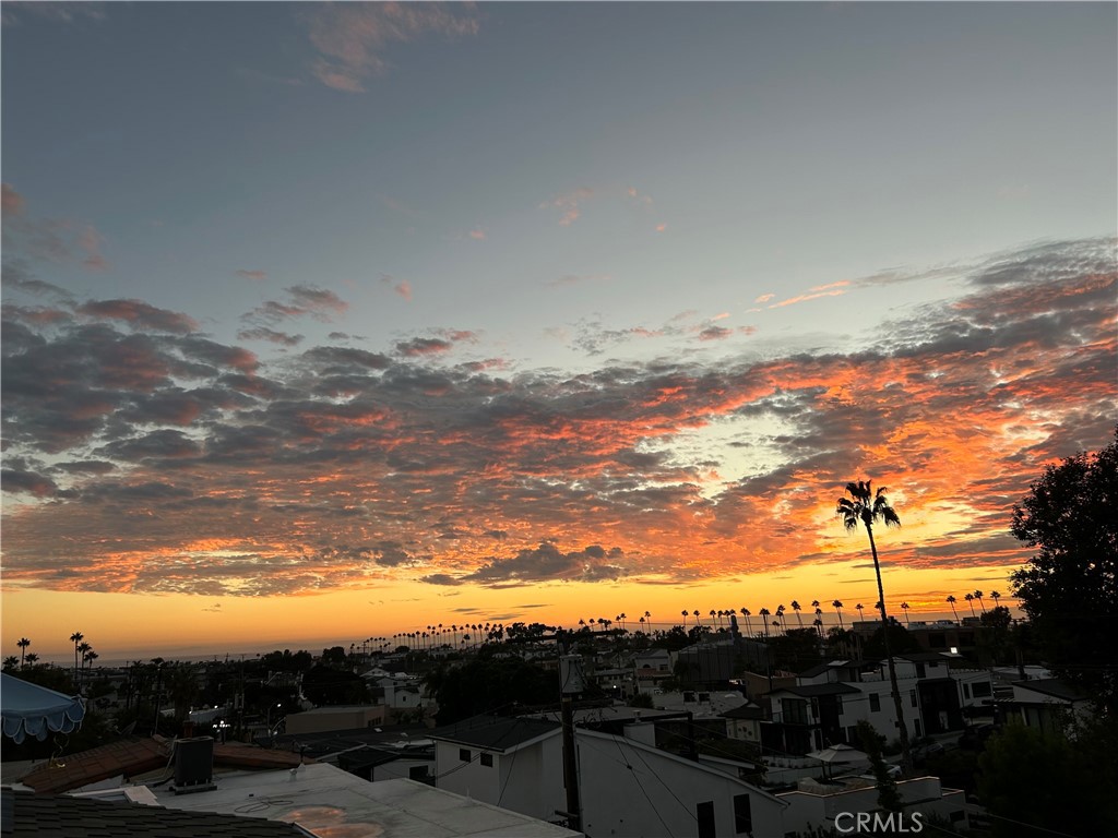 SPECTACULAR ROOFTOP SUNSETS AWAIT YOU! Located on the highest point of Jasmine in the Corona Del Mar village flower streets, 611 1/2 Jasmine is a newer construction modern farmhouse back unit that's larger than many front units. You’ll love the 700sf of bonus space that has been transformed into three separate rooms --perfect as a gym and massive closet/storage, or a theater/ family room with office and storage! An elevator transports you from the garage to the main entry level, great for groceries, luggage and easy accessibility. The airy living room is flooded with light, and centers around a stone fireplace, and opens to an outdoor terrace with sliding glass panels, effortlessly bringing the outdoors in! A sleek kitchen with farmhouse sink, custom cabinetry and pendants makes entertaining easy with a Wolf range, custom hood, and a Sub-Zero refrigerator. The ample kitchen island provides extra seating, while a custom peninsula bar area with tons of storage, a pantry, wine refrigerator, and floating shelves make this both home functional and stylish. The primary suite includes automated shades, a spacious shower, soaking tub, Brizo fixtures and a dual vanity. The spacious bedroom suites are the epitome of style with white oak, custom built vanities, custom mirrors and top-of-the line Brizo fixtures. A finished garage, elevator, and gorgeous sunset views await you on the rooftop deck where a barbecue, built-in speaker and extra storage add to this home's tremendous appeal.