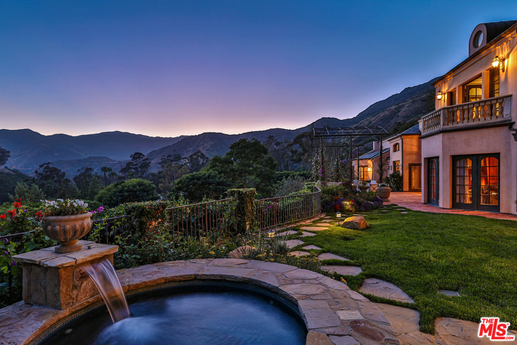 Soaring above the Pacific in Malibu's prestigious, guard-gated Serra Retreat, this French country-inspired celebrity compound showcases breathtaking ocean and mountain views on nearly five acres. The resplendent property features a 7,814-SF main residence replete with a gourmet kitchen designed by Wolfgang Puck, climate-controlled wine cellar, wood-paneled library and expansive master suite with a private sitting room, ocean-view balcony and luxurious bathroom. A magnificent two-story ballroom, crowned by an elaborate crystal chandelier, is poised for grand entertaining. The compound features a six-stall equestrian facility, riding ring, outbuildings, carriage house, security outpost, cinema, exercise room and staff quarters. Ethereal, old-world grounds are immersed in the stunning coastal canopy, including a resort-style pool and bathhouse, two outdoor spas, tennis court, barbecue area with fireplace, organic vegetable garden, fruit orchard, rose gardens and Monet-inspired lily ponds.