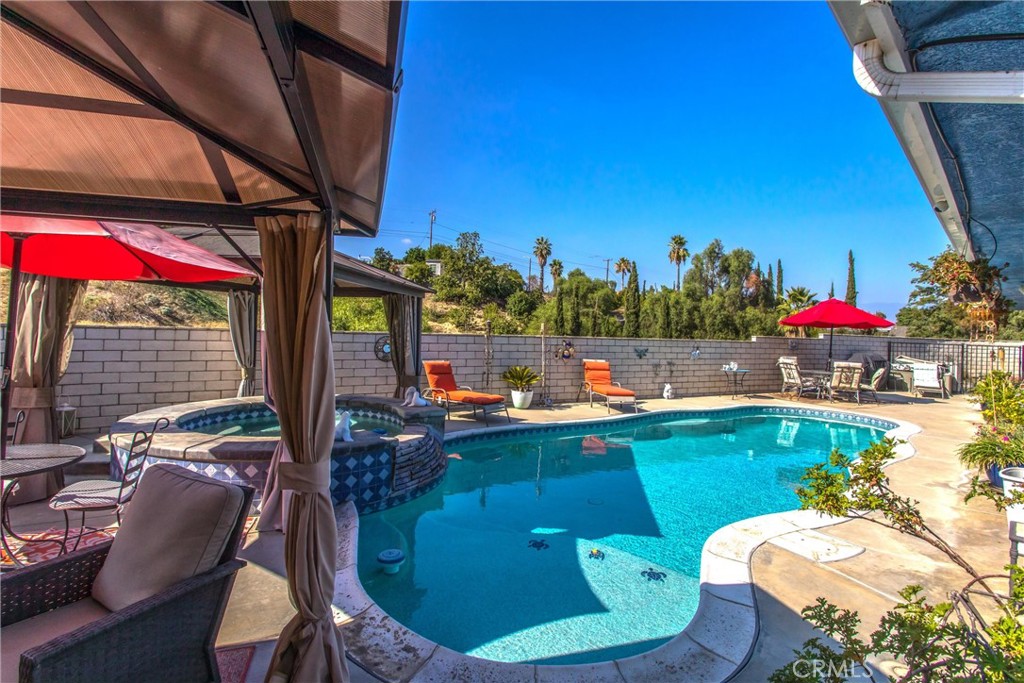 Priced to Sell – Custom Home with Acreage, Pool, and Solar in Loma Linda. Nestled in a quiet hillside neighborhood of Loma Linda, this custom 3-bedroom, 2-bathroom home offers 1,969 sq. ft. of thoughtfully designed living space on 1.69 acres of landscaped property. Built in 2004, the home blends comfort, efficiency, and style with modern upgrades throughout. KEY FEATURES ** Custom-built in 2004 - designed for comfort and style with 9-foot ceilings and spacious rooms. 3-Car Garage: Plenty of room for vehicles and storage; Fire Sprinkler System and septic system with extra-large tank. ENERGY EFFICIENT ** 27 owned and paid-for solar panels installed in 2010; 50-gallon water heater installed in 2023; Independent dual air conditioning systems with thermostats UPGRADED AND MOVE-IN READY ** New flooring in hallways, bathrooms, and kitchen in 2022; New roof in 2019; Granite kitchen countertops installed in 2016. BEAUTIFUL INTERIOR ** 2 Gas Fireplaces: Located in the living room and primary bedroom; Primary Suite: Walk-in closet, jacuzzi-style tub, and patio access; Kitchen: Plenty of cabinet space, pull-out shelving and modern finishes; Wood Shutters and ceiling fans throughout to keep the home cool and comfortable. OUTDOOR PARADISE WITH LANDSCAPING ** Fruit trees and lush greenery and two-rail white fencing and automatic sprinklers. Covered outdoor space that is accessible from the living room and primary bedroom. Pool and spa with a gazebo built in 2010 with solar-heated pool for year-round enjoyment. LOCATION: A custom home in Loma Linda in the renowned Blue Zone – known for longevity and quality of life! Near Loma Linda University Medical Center and VA Hospital, and minutes to shopping and dining.