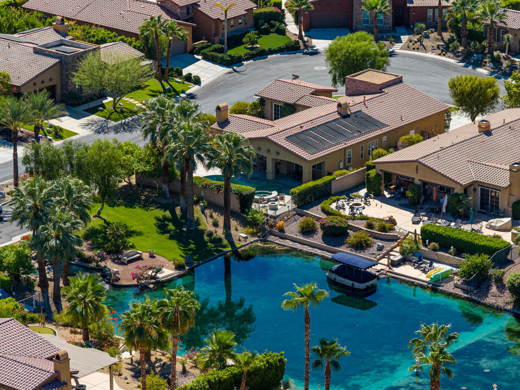 Location, location, location! Discover rare Lake-Side Living at its finest on a prime lot at Santo Tomas Community! You're invited to this exceptional three-bedroom, three-bathroom home with the most charming of pool areas with views upon the pristine lake and Mountains beyond.In this entertainer's home you find tile flooring throughout, and its centerpiece is a main living area with a well-appointed kitchen with stainless steel appliances, convenient bar seating, and an adjacent dining area with fireplace. The living room provides the perfect gathering space of its own, with fireplace, integrated speaker system, and seamless access to a paved outdoor entertaining areas through a row of sliding doors.The primary suite serves as a private retreat, offering direct pool access, dual vanities, soaking tub, separate shower, and an impressively sized walk-in closet. Two additional bedrooms provide flexible living options, with the front bedroom ideally suited for a home office.Outside is the most charming of pool areas, and given the property's unique positioning, offers captivating canal views and enchanting west-facing mountain vistas, all to the soundtrack of a waterfall in an adjacent park.Recent improvements include replacement of HVAC units just three years ago, a 2023 pool solar heater and more. HOA that includes: gated entry, lake maintenance, road upkeep, and exclusive access to Mission Hills Country Club amenities tennis, pickleball, fitness facilities, and dining options. We invite you to experience this superbly located Santo Tomas property.