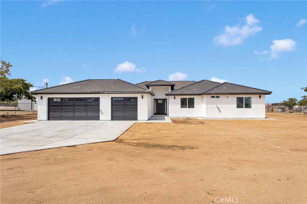 Introducing 16212 Mesquite St in Hesperia, CA—a beautifully crafted new construction home that blends bold design with everyday comfort. Offering 2,413 square feet of living space, this residence features 4 bedrooms and 2.5 bathrooms on a full 1-acre lot. The interior showcases modern accents throughout, highlighted by luxury laminate flooring and a striking custom two-tone kitchen with quartz countertops, sleek finishes, and statement lighting that elevates the heart of the home. The primary suite serves as a private getaway with a walk-in closet and a spa-like bathroom complete with a double vanity sink, soaking tub, and separate shower. A three-car garage, laundry room, and inviting back patio enhance everyday living, while the cozy electric fireplace with custom paneling adds a stylish focal point to the living area. Energy-efficient solar panels provide long-term value, and the convenient location—just minutes from Hesperia City Hall, Victor Valley Mall, and the I-15—makes this home the perfect balance of modern style, thoughtful design, and accessibility.