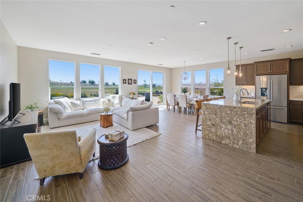 Step into unparalleled elegance with this single-level Solvang model, perched on a premium almost 11,000sf vineyard and mountain view lot in Trilogy at Monarch Dunes. Nestled at the end of a quiet cul-de-sac, this 2-bedroom plus office, 2-bathroom SOLAR and SMART home exudes the effortless sophistication of a model home, with tile floors, neutral palettes, & abundant natural light. The award-winning floor plan centers around a spacious great room with soaring ceilings, seamlessly connecting to a stunning kitchen featuring a custom waterfall-edge island, quartz countertops, top-tier GE Profile appliances, reverse osmosis system plumbed into fridge & spigot, five-burner gas stove, and stained maple soft-close cabinetry with pull-out drawers. A large pantry & oversized laundry room with desk and ample storage add both function and style. The primary suite is a serene retreat, offering breathtaking vineyard and mountain views, high ceilings, a spa-like bath with dual sinks, quartz countertops, walk-in shower with bench and decorative tile, & an expansive walk-in closet. The guest wing includes a corner bedroom with two large windows, a bath with soaking tub/shower combo, and an office , perfect for work, study or even a 3rd bedroom! Designed for modern living, this smart home features sophisticated automation: lighting with dimmers, thermostat, solar, water heater, appliances, remote entry, and voice activation via Alexa and Siri, along with Ring, MyQ, Rachio irrigation, internet booster for outdoor WIFI coverage, smart HQ, and programmable outdoor lighting/fountain. Step outside to your private resort: four distinct patios for alfresco dining, sun lounging, yoga, or morning reading, surrounded by lush, low-maintenance landscaping with beautiful fountain setting a peaceful tone with rose and veggie gardens, five fruit trees, and panoramic vineyard and mountain vistas. Stone accents, paver driveway, and southern exposure complete the idyllic setting. Live the Trilogy lifestyle with championship golf, fine dining, luxury spa, state-of-the-art fitness, and endless social opportunities. Relax in the expansive backyard and enjoy sweeping views of wildflower meadows and even NASA and SpaceX launches from Vandenberg. Golf course community with all the amenities right at your fingertips & just five miles from Oso Flaco Lake State Park dunes and beaches. Exceptional design, luxury, and technology converge to create a home that’s more than a residence—it’s a lifestyle.