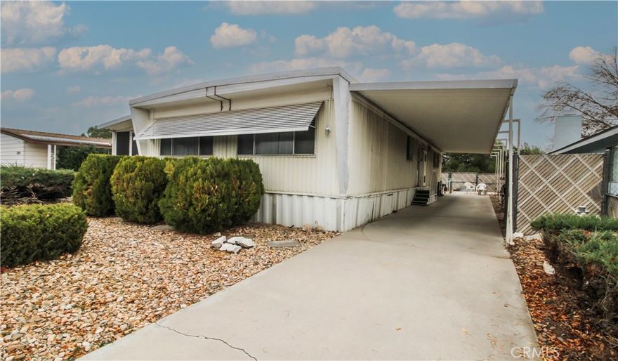 Golf Course Home! Own a Manufactured Home on your own land.  NO lease fees, NO HOAs! Home is well maintained and right on the golf course.  This home is a roomy 2 bedroom that can easily be turned into a 3 bedroom. Featuring a formal dining area, wet bar and indoor laundry.  Kitchen has a breakfast bar and a newer stove, extra large living room features two large window allowing natural lighting to flow in. This home is fully equipped with a covered carport the full length of the home stretching to 60ft, giving plenty of room for your vehicles. On the other side also stretching the full 60ft is an enclosed sunroom, ready for your indoor garden, sitting area, playroom, or whatever you desire.  The backyard contains a large storage shed for any extra storage needs you may have.  Upgraded with a newer A/C unit and Roof, the rest is left for your creative touch.  Call now for your own private tour.