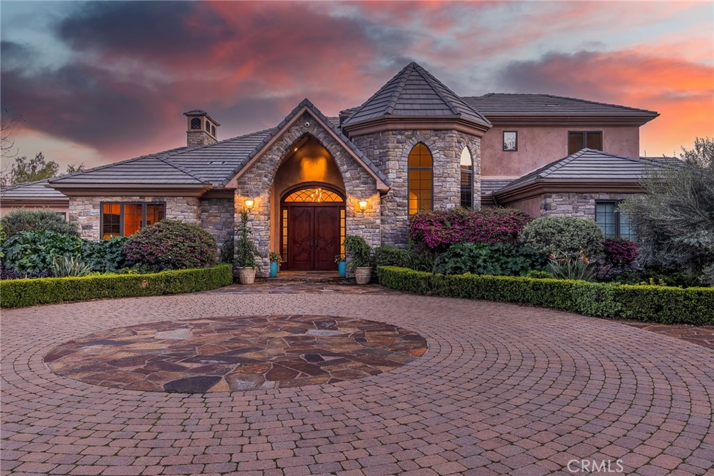 Experience exquisite luxury living in this recently renovated Fallbrook masterpiece. With 4,963 Sq.Ft. of living space, this custom-built home is a testament to quality and timeless attention to detail. From the African Mahogany double arched entry doors to the 10' ceilings, every detail exudes elegance. Mahogany and cherry wood high-arched doors w/ antique brass hardware grace the interior. Every inch of wood throughout has been meticulously refinished to perfection showcasing the attention to detail! The great room features a new fireplace with a raised hearth, wood mantle, stone facing and travertine flooring all of which complement the grand feel of this room along with massive wood beam ceilings. Your gourmet kitchen boasts Viking appliances inclusive of double ovens, Sub-Zero refrigerator, new countertops/fixtures/lighting & large island perfect for entertaining. The primary suit spares nothing in character offering expansive views, new casework, backlit Cristallo Quartzite fireplace, walk in closet and huge bathroom with dual sinks, soaking tub with views and large walk in shower! Additional features include a wine closet, game/media room that has undergone a complete renovation inclusive of custom casework/wetbar/Sub-Zero wine cooler, Smart Home Savant audio/video entertainment system & Lutron lighting system. Efficiency meets sustainability with Solar PV systems allowing for off grid living if needed, propane high-efficiency tankless water heater and Tesla battery-backup. This home is equipped with 12-gauge copper electrical wiring & an L-grade copper water piping system, attesting to its quality construction. A detached 900 Sq.Ft. workshop is a perfect addition for hobbyists & DIY enthusiasts or gives additional space for all your toys. Below the workshop a second large workspace is perfect for crafting, indoor/outdoor bar or anything your heart can dream up! A craft vineyard offers ample vines and certified organic Hass Avocados all meticulously controlled by your private well. Sitting on 8.45 acres if outdoor living is what gets you excited get ready for the new Pebble-Tech XL spa, BBQ, pond, turf, vaulted covered patio with exposed beam interior, lush mature landscape and park-like backyard with walking trails, orchards, garden, gazebo, mature oak trees and stunning views you can savor from the upper-level balcony, primary quarters or from the comfort of your living room. Enjoy Fallbrook living truly at it's finest!