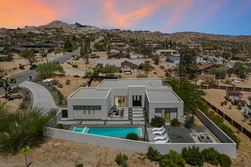 Come and see your desert resort home! Modern 3-bedroom, 3.5-bath home with breathtaking mountain views in a peaceful rural setting. This turnkey property features soaring ceilings, an open floor plan, and stylish built-in details throughout. The chef's kitchen impresses with a large quartz island, walk-in pantry, and premium appliances including gas cooktop, oven, microwave, and refrigerator. The luxurious primary suite offers a soaking tub, walk-in shower, double sinks, quartz counters, and a spacious walk-in closet. Sliding doors open to a private backyard retreat with in-ground pool, spa, and outdoor fire pit--perfect for relaxing or entertaining. Additional highlights include central air/heat, concrete floors, inside laundry, privacy fencing, desert landscaping, and a covered patio. An attached 2-car garage with driveway parking adds convenience. The home is currently on septic with a public sewer connection scheduled by late August. This stunning home blends modern design, everyday comfort, and resort-style living.