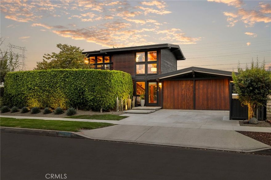 A rare and remarkable interpretation of Cliff May’s vision, this expanded Rancho Estates residence pushes the boundaries of classic California modernism while preserving every ounce of its soul. Nearly 2,300 square feet of thoughtfully designed space unfold across two levels, offering a flexible and functional floor plan that lives large without losing the intimacy and indoor-outdoor harmony that define May’s work. Here, space is never a compromise, it’s a celebration. The home’s post and beam architecture creates distinct zones for connection and retreat, with 3 spacious bedrooms, 3.5 baths, a dedicated office / creative space, and 3 versatile living areas. The flow is effortless: a formal living room, den, and expansive great room each open directly to the central courtyard, where sunlight and firelight blur the boundaries between inside and out. A minimalist chef’s kitchen with a quartz-topped island anchors the main living space, ideal for both daily life and entertaining, while a well-appointed butler’s pantry and laundry area with additional sink and counter space adds everyday practicality. Each room extends into its own outdoor experience, amplifying the home’s connection to nature. The upstairs suite features a sunny private balcony, the front bedroom opens to a tranquil meditation garden and infrared sauna, and the great room connects to an ipe deck built for entertaining, a glowing central courtyard with firepit and a striking heated lap pool. The home’s expansion delivers not just square footage but an elevated lifestyle: a serene primary suite with dual closets and ensuite full bath, a flexible upstairs wing with kitchenette and balcony perfect for guests or your creative makerspace. Presenting a truly turnkey opportunity, countless modern upgrades elevate the appeal of this special property: owned solar, EV charging station, tankless water heater, advanced water purification and softening systems, outdoor audio system, security system, modern central HVAC with ductless mini-splits, upgraded pool equipment, and creative built-in storage solutions. Set on a tree-lined and tranquil street just moments from the 800-acre El Dorado Park and nature preserve, 3110 Pattiz Ave embodies the Rancho Estates ethos: architectural authenticity, a deep connection to the outdoors, and a lifestyle that’s both relaxed and refined. This is where mid-century design meets modern life and where space, style, and soul come beautifully together.