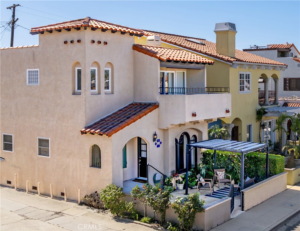 Welcome to your dream home in the coveted neighborhood of Belmont Shore—a beautifully re-imagined Spanish home that perfectly blends classic charm with modern upgrades. Step inside and be captivated by the warmth of this home, where original details meet contemporary comfort. The charming Dutch entrance door has a built-in screen to allow the nice breeze to come in while the gorgeous large arched picture windows flood the living spaces with abundant natural light. Downstairs offers the refinished hardwood floors, a living room with a gorgeous, cozy, remodeled gas fireplace with Spanish accent tile and a wall vent to the roof. A beautifully maintained original hall bath offers comfort and charm for guests. A generously sized kitchen that has been thoughtfully remodeled with an abundance of cabinets, stainless-steel refrigerator and stove and a nice big window that brings all the beautiful natural light and newer cement board floors in the kitchen and dining area. The elegant, remodeled stairs bring you up to the 2nd floor to a beautiful spacious master suite that offers a private retreat with built-ins, recessed lighting, four closets offering plenty of space for storage, brand new carpet and a spa-like bathroom with an oversized bath to soak in and relax, a separate shower, two vanities and storage cabinets for all your linens and a Samsung A/C split unit. Upstairs also offers a nice size bonus room that can be used as a guest bedroom or an office with access to a balcony where you can enjoy the breeze and relax as well as a convenient hallway bathroom for your guests. The attached two car garage offers steel storage racks, a newer motor for electric garage door and provides direct access to the kitchen area making it very convenient to bring your groceries in! Other great upgrades include interior painting, upgraded electrical panel and plumbing, central air and heat, resurface coating Spanish tile roof, newer water heater and custom drapes and blinds throughout all windows. Outside, a private patio provides a wonderful space to relax and enjoy the ocean breeze. Set up your umbrella and a comfortable seating area to soak up the sun. Located just a short walk or bike ride from Bayshore, dining, and boutique shopping, this home invites you to fully embrace the vibrant beach lifestyle Belmont Shore is known for, it is a wonderful place to call home. Come see it and fall in love with this beautiful beach home.