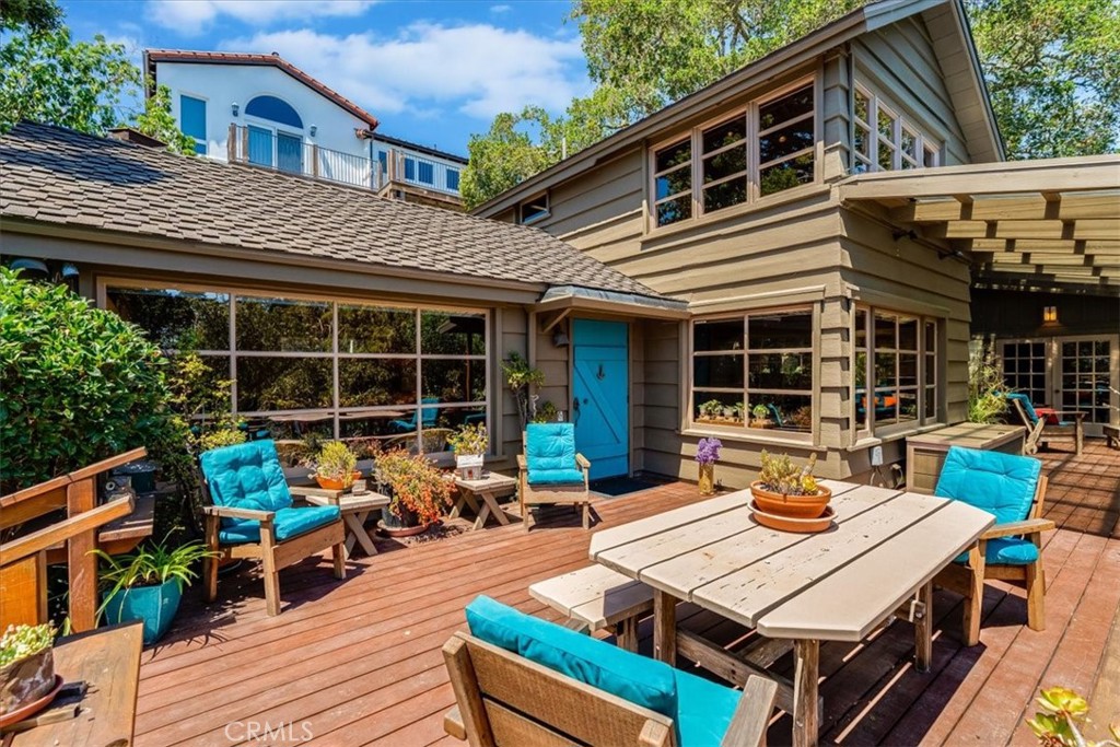 This home is a quintessential cottage in the woods and it is less than a mile from the ocean. Built upon 8 ocean view lots on Lodge Hill, this south facing home is surrounded by a secret garden of mature oaks, ferns and meandering pathways. It is an artistic cottage, beckoning you to create, to be a maker. Built in 1951 its most recent owner was Eleanor and Henry Kluck, a prolific and famous textile designer and an architect. This home inspires, it has an aura of creativity, it feels like a secret space in a hidden world. The large deck surrounding the home is an integral part of its function providing outdoor living space open to the sky, and access to the guest home and studio under the covered section. A giant Oak tree stands guard between the main home and the guest area. All of it has sweet ocean views. The home and guest home are a wonder of wood and have a feeling of yesteryear. Knotty pine wood walls, vaulted and beamed wood ceilings, and wood windows. A peek of ocean view is had from most windows. The main home has a corner brick fireplace in the living room, while just around the corner, the kitchen and dining room are combined into an open space with views to the deck, the trees, the sea. There is a walk-in pantry and a door to the deck. The primary suite is up one flight of stairs, providing wonderous views of the trees, gardens and ocean. Functional closets are tucked everywhere, hidden to look like the wood walls. Across the deck is the guest portion and studio of the property. Two Bedrooms, one bathroom in the guest quarters. Once again, wood walls, angled wood ceilings, clerestory windows, ocean view, and double French doors lead to the deck. Below this is a 425 sq ft art studio with half bathroom. Part of the studio is a glass atrium capturing sunlight and inspiration. Much of the property is undeveloped and private. There are two sheds for outdoor storage and many areas to sit in the sun or dappled sunlight.