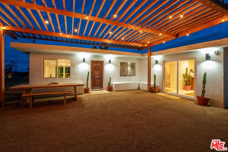 Escape to SunDream; A Yucca Valley Oasis with Stunning Views and Unique Charm. Welcome to SunDream, a breathtaking two-bedroom, one-bath home nestled in the serene Yucca Valley. Perched on a sprawling 5-acre lot, this property offers an unparalleled connection to the natural beauty of the desert, with 100-mile panoramic views stretching from the snow-capped peaks of Big Bear to the rolling High Desert. One of SunDream's standout features is the unique glass pool, perfectly oriented east to west to capture the radiant desert light. Imagine floating at sunrise or sunset, surrounded by the glowing hues of Monet-like desert skies, ancient 150-year-old Joshua trees, and the calm of the landscape. Designed to embrace the outdoors, SunDream boasts five custom sliding windows that invite the desert's beauty into every room. The living room is a cozy retreat with a fully functional wood-burning fireplace and a luxurious Lovesac deep-seat 'cloud' sectional perfect for relaxation or accommodating an overnight guest. Step through a hidden bookshelf door to discover the guest bedroom, featuring a Queen-sized Casper bed with views of the stunning eastern mountain range. The main bedroom offers a King-sized Casper bed and sliding windows framing the outdoor desert shower. This seasonal outdoor shower is not only luxurious but eco-conscious, with biodegradable soaps and flagstone tiles ensuring water nourishes the surrounding succulents. The Pink Princess bathroom is an unforgettable spa-like sanctuary, wrapped in soft pink tile with gold accents. Featuring a dual shower and soaking tub, it's an ideal space to unwind after a day exploring the desert. The front patio and dining area, accessible from both the kitchen and living room, is the perfect spot to dine al fresco or simply immerse yourself in the peaceful surroundings. Whether you're looking for a serene getaway or a dream home to fully embrace desert living, SunDream offers it all, tranquility, luxury, and a one-of-a-kind connection to Yucca Valley's magical landscape.