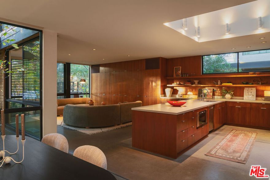 Architectural masterpiece in Venice, designed by renowned architects Marmol Radziner for Leo Marmol himself. This spectacular home offers 3 bedrooms, 3 bathrooms, plus a screening room and an office, all with warm modern organic design, sophisticated finishes, and unparalleled craftsmanship. This residence was designed with indoor-outdoor flow in mind.  The interior features walnut cabinetry, Heath ceramic tiles in the bathrooms, and expansive walls of glass that bathe the home in natural light while connecting the refined living spaces to the lush, private gardens. The dramatic double-height chef's kitchen is a culinary dream, complemented by an open living/dining area perfect for entertaining. All three bedrooms are found upstairs. Outdoors, enjoy an approx 700 SF covered living space with a fireplace, ceiling heaters, and a landscaped backyard. Located just two blocks from Abbot Kinney's boutiques, galleries, and restaurants, and minutes from the beach, this gated property offers the ultimate Venice lifestyle- a private retreat designed to recharge and inspire.