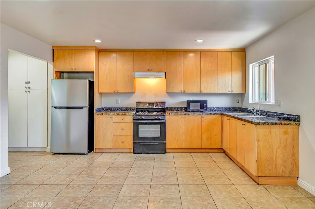 Welcome to this bright and spacious 1-bedroom, 1-bathroom apartment offering approximately 900 square feet of comfortable living space. Thoughtfully designed with functionality in mind, this unit is move-in ready and filled with natural light.
The open kitchen features sleek granite countertops, ample cabinet storage in warm natural wood tones, and appliance including a gas stove. Overhead recessed lighting and a large window by the sink keep the space light and airy, making it ideal for everyday cooking and entertaining. The bedroom is generously sized with tile flooring throughout, a large window for natural light, and a built-in wall A/C unit for added comfort. You'll love the extensive built-in closet system featuring drawers, cabinets, and hanging space — perfect for staying organized. The bathroom is clean and well-appointed with a subway-tiled shower/tub combo, granite vanity counter, and modern fixtures. The warm wood cabinetry provides extra storage while keeping the space inviting.