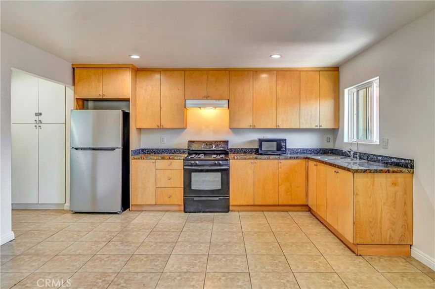 Welcome to this bright and spacious 1-bedroom, 1-bathroom apartment offering approximately 900 square feet of comfortable living space. Thoughtfully designed with functionality in mind, this unit is move-in ready and filled with natural light.

The open kitchen features sleek granite countertops, ample cabinet storage in warm natural wood tones, and appliance including a gas stove. Overhead recessed lighting and a large window by the sink keep the space light and airy, making it ideal for everyday cooking and entertaining. The bedroom is generously sized with tile flooring throughout, a large window for natural light, and a built-in wall A/C unit for added comfort. You'll love the extensive built-in closet system featuring drawers, cabinets, and hanging space — perfect for staying organized. The bathroom is clean and well-appointed with a subway-tiled shower/tub combo, granite vanity counter, and modern fixtures. The warm wood cabinetry provides extra storage while keeping the space inviting.