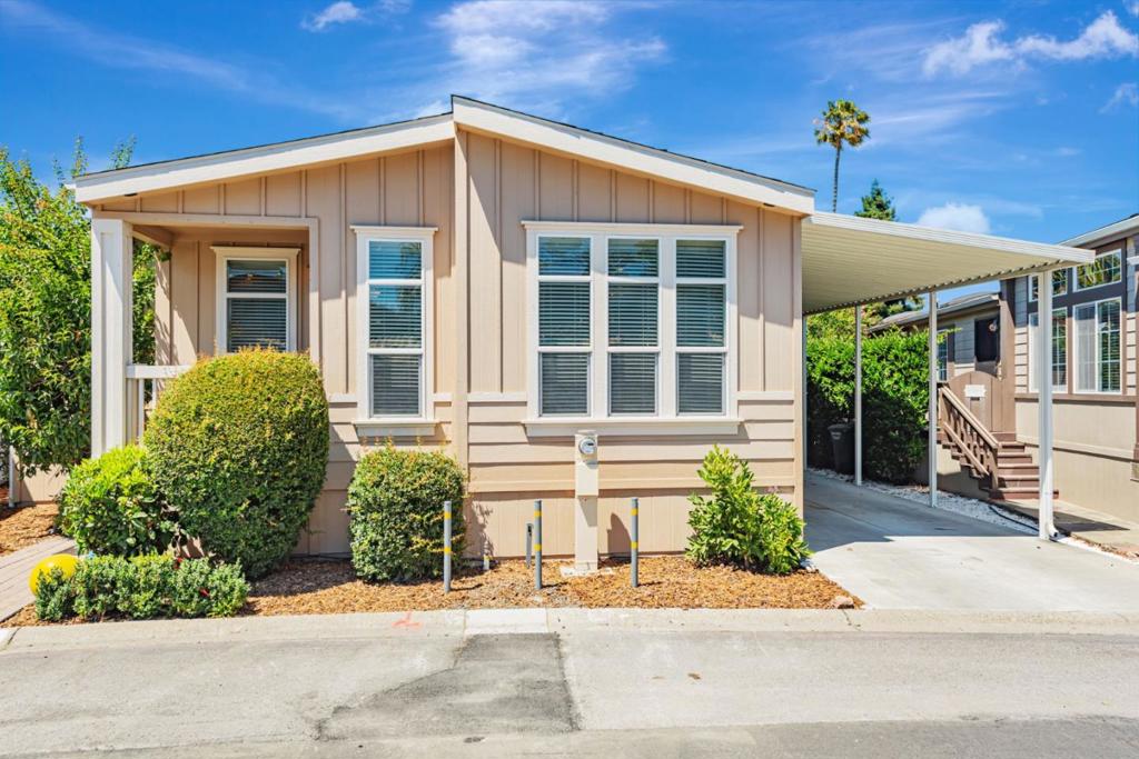 Spacious & beautifully maintained 3-bedroom, 3-bath, plus den, triple-wide manufactured home, situated across from the community clubhouse, swimming pool, and recreation area. This rare home offers comfortable living space with an open floor plan, high ceilings, & abundant natural light throughout. Step inside to a welcoming foyer entry leading to a large living room with coffered ceiling, gas-burning fireplace & expansive windows. The open kitchen features a central island, stainless steel appliances, abundant cabinetry, and a convenient layout perfect for cooking & entertaining. A separate office/den provides ideal space for home office or hobby room. The primary suite is a true retreat, complete with a spacious walk-in closet, private sliding door access to the backyard, and a spa-like bathroom with dual vanities, a jetted sunken tub, and a separate tile shower. The junior suite includes its own ensuite bath and walk-in closet perfect for guests or multigenerational living. Additional highlights include: air conditioning, indoor laundry with washer/dryer, ample hallway storage, fenced backyard with fruit trees, and a storage shed. Enjoy resort-style amenities just steps away, and easy access to HWYs 101, 237, and 85, Levis Stadium, tech campuses, shopping, and VTA Light Rail.
