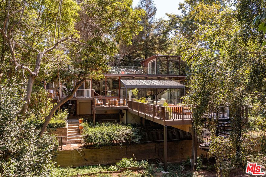 Beyond a gated entrance in Rustic Canyon, this exceptional and unique property unfolds across over 3/4 of an acre of land, with organically landscaped grounds, offering a rare blend of architectural distinction and natural beauty.  This residence (5 bedrooms/5 baths) and brand new kitchen -is a bold and timeless architectural statement, with soaring lines and walls of glass that invite in light and frame tranquil vistas.  (A separate guest house is also available for sale with this property). A picturesque creek winds through the property creating a meditative backdrop for daily living.  Expansive terraces and garden pathways  invite gatherings and natural settings for reflection. Designed for those who value balance, this estate embodies a retreat-like atmosphere - equally suited for spiritual renewal and entertaining. This is a rare opportunity to own an exclusive estate where architecture, lifestyle and nature exist in perfect harmony. A must see!