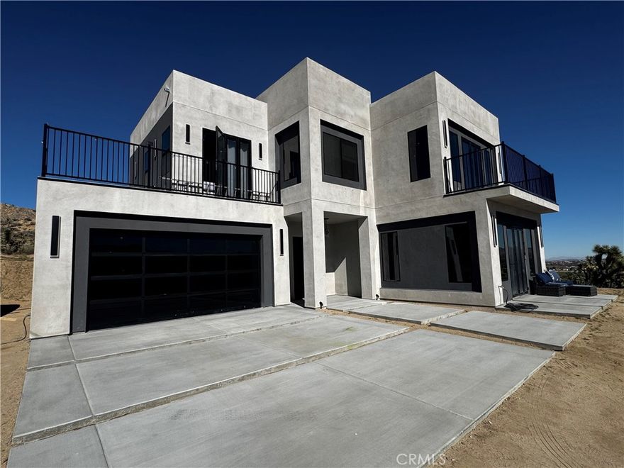 Brand-New Modern Luxury Home in the Coveted Country Club Area of Yucca Valley!
Perched above the golf course on a rare 1.25-acre lot, this stunning contemporary home is currently under construction and expected to be completed in early 2026. Designed with modern sophistication and high-end finishes throughout, this property offers exceptional quality, privacy, and panoramic views of Mt. San Jacinto and the surrounding desert landscape.

Step through the impressive tinted tempered glass 8-ft pivot door into an open-concept living space featuring 10-ft walls, coffered ceilings with LED lighting, and 8-ft folding patio doors that create seamless indoor-outdoor flow. The chef’s kitchen boasts a massive 7’x7’ quartz island, full quartz slab backsplash, Cosmos stainless steel appliances, custom soft-close cabinetry, and LED-lit floating shelves.

Additional highlights include polished concrete and engineered wood floors, black metal and glass stair railings, two 60” electric fireplaces, and zoned AC/heat pumps for every room. Each bedroom offers its own spa-style bathroom with LED mirrors, electric toilets, and designer tile showers. The luxurious primary suite features a sitting area, large walk-in closet, and private balcony with sweeping desert views.

Energy efficient touches include solar readiness with battery connection, foam-insulated roofing, and a 50-gallon electric heat pump water heater. Outside, enjoy nearly 100 protected Joshua Trees, a circular driveway, a new septic system, and a 20’x30’ concrete pad ideal for a future pool, fire pit, or Ramada.

A rare opportunity to own a cutting-edge, all-electric modern masterpiece in one of Yucca Valley’s most desirable neighborhoods—just steps from golf, hiking trails, and the country club!