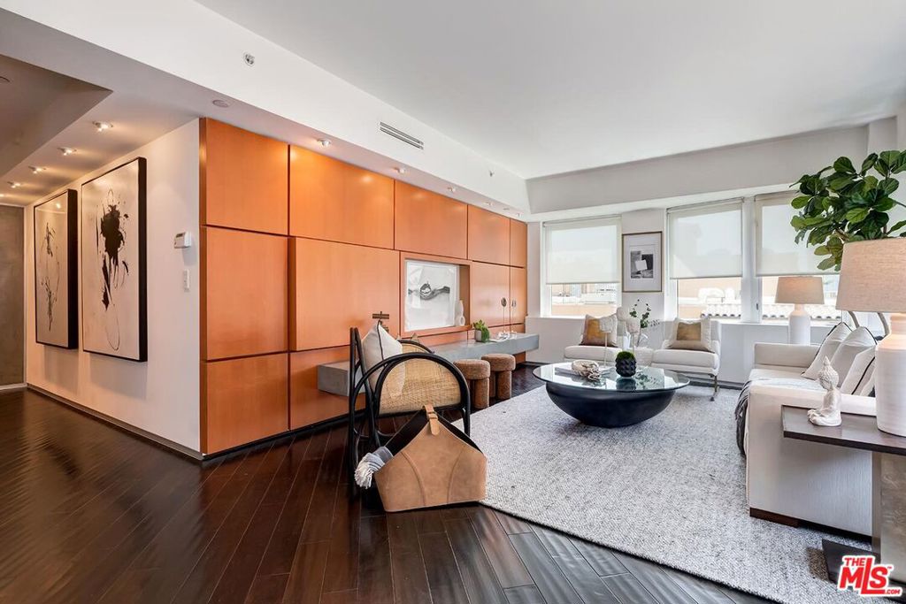 Step into an atmosphere of calm elegance in this rear-facing, designer-renovated residence at The Dorchester-an icon of full-service living on the Wilshire Corridor. This expansive two-bedroom, two-and-a-half-bath retreat offers over 2,200 square feet of refined interiors and curated detail. A rare offering that seamlessly blends Japanese-influenced architecture with modern comfort, this unit features floor-to-ceiling shoji screens, espresso-toned hardwood floors, and custom paneling that anchors a gallery-style living space filled with soft natural light. The open-concept kitchen is a study in clean lines and efficient luxury-framed by glass and wood-front cabinetry, integrated stainless appliances, and sleek stone countertops-all flowing effortlessly into the dining area and lounge. The primary suite is a sanctuary unto itself: elevated bed platform, additional shoji screens, and a spa-inspired bath with dual sinks, infinity-edge soaking tub, large shower, built-in vanity, and tranquil glass tilework. Two generous walk-in closets offer exceptional built-in storage. The secondary bedroom suite is equally refined, with custom millwork, a built-in hideaway desk, and a private ensuite bath. A full-size laundry room with utility sink and cabinetry completes the interior. Building amenities include 24-hour concierge, valet, rooftop pool with panoramic views, fitness center, sauna, conference room, and secure access. Ideally located minutes from UCLA, Westwood Village, Beverly Hills, and Century City. A rare offering of harmony and sophistication in one of L.A.'s most coveted high-rises.