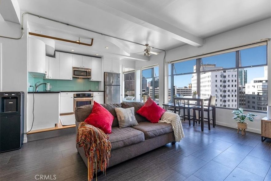 Welcome to this stylish mid-century modern condo in the heart of Downtown Long Beach! Located in the iconic Royal Palms building, this 2-bedroom, 1-bath residence offers 820 sq. ft. of thoughtfully designed living space with sweeping city views and a peek-boo view of the Queen Mary through oversized windows that flood the home with natural light. This is a end unit with only one shared wall.
Step inside to find an open-concept floor plan featuring a modern kitchen with sleek cabinetry, granite countertops, glass backsplash, stainless steel appliances, and ample storage. RARE IN UNIT LAUNDRY! The spacious living and dining areas create the perfect space for entertaining or relaxing while enjoying the skyline views. Both bedrooms are generously sized, with the primary suite offering plenty of room for a retreat. The bathroom has been updated with a modern vanity, Full slab granite shower-tub combo, and vessel sink.
This pet-friendly community includes 24 hour surveillance and an elevator with secure access required after hours, a refreshing pool, outdoor lounge areas, BBQ space, and laundry facilities. Perfectly situated on the corner of Atlantic Avenue and 1st Street, you’re just moments away from the beach, Shoreline Village, Pike Outlets, coffee shops, and award-winning restaurants. Easy access to public transportation and major freeways makes commuting a breeze.
With its unbeatable location and vibrant downtown lifestyle, this condo offers the perfect blend of comfort and convenience.