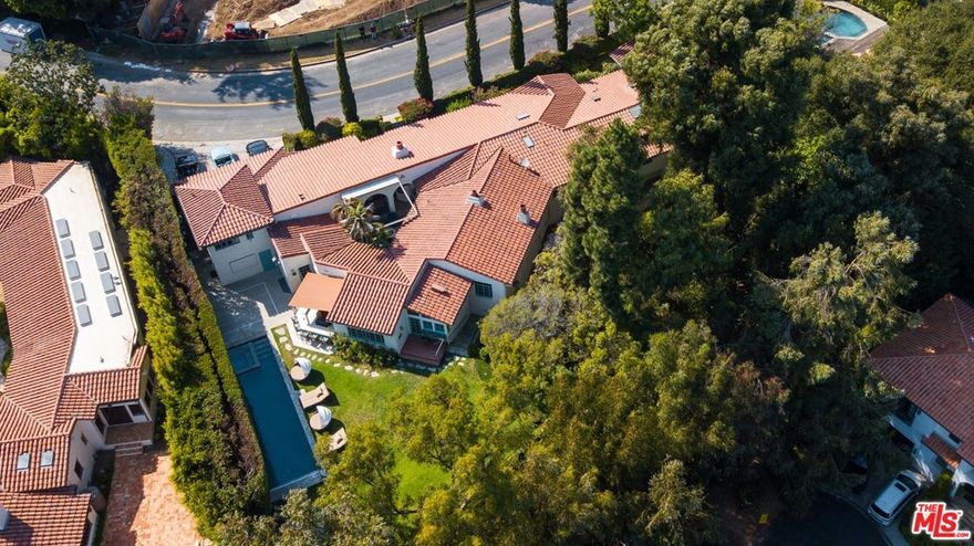 Authentic original 1935 single-story Spanish hacienda remodeled and designed by acclaimed architect Thomas Calloway, alongside talented designer Nancy Heller. Boasting over 1/2 acre of land & most notably its' own private and separate access 25+ person plush 1,152 SF movie THEATER; complete w/ sound proof, DOLBY sound system & private control room. Located on one of LA's most prestigious streets of lower Tigertail, this home blends romantic old world charm w/ modern, top of the line amenities, appliances Throughout the main residence you will discover the warmth & charm that only an original Spanish home can offer. With hardwood floors & open beamed ceilings, this home has a one of a kind decor, creating a fun and iconic rockstar atmosphere. The floor plan of the house provides a private setting surrounding a romantic atrium w/ automatic cover to enjoy day & night, rain or shine, w/ outdoor pizza oven & heat lamps. Inside the home is a large family/living room combination, currently providing two sitting areas & billiard room, w/ decorative large gas starting & wood burning fireplace. The formal dining room comfortably sits 12 adjoining a large, nostalgic vintage bar, overlooking yard, pool & spa and 1/3 basketball court. One guest suite is separated from the other bedrooms, providing a great in-laws / staff or teenagers suite.